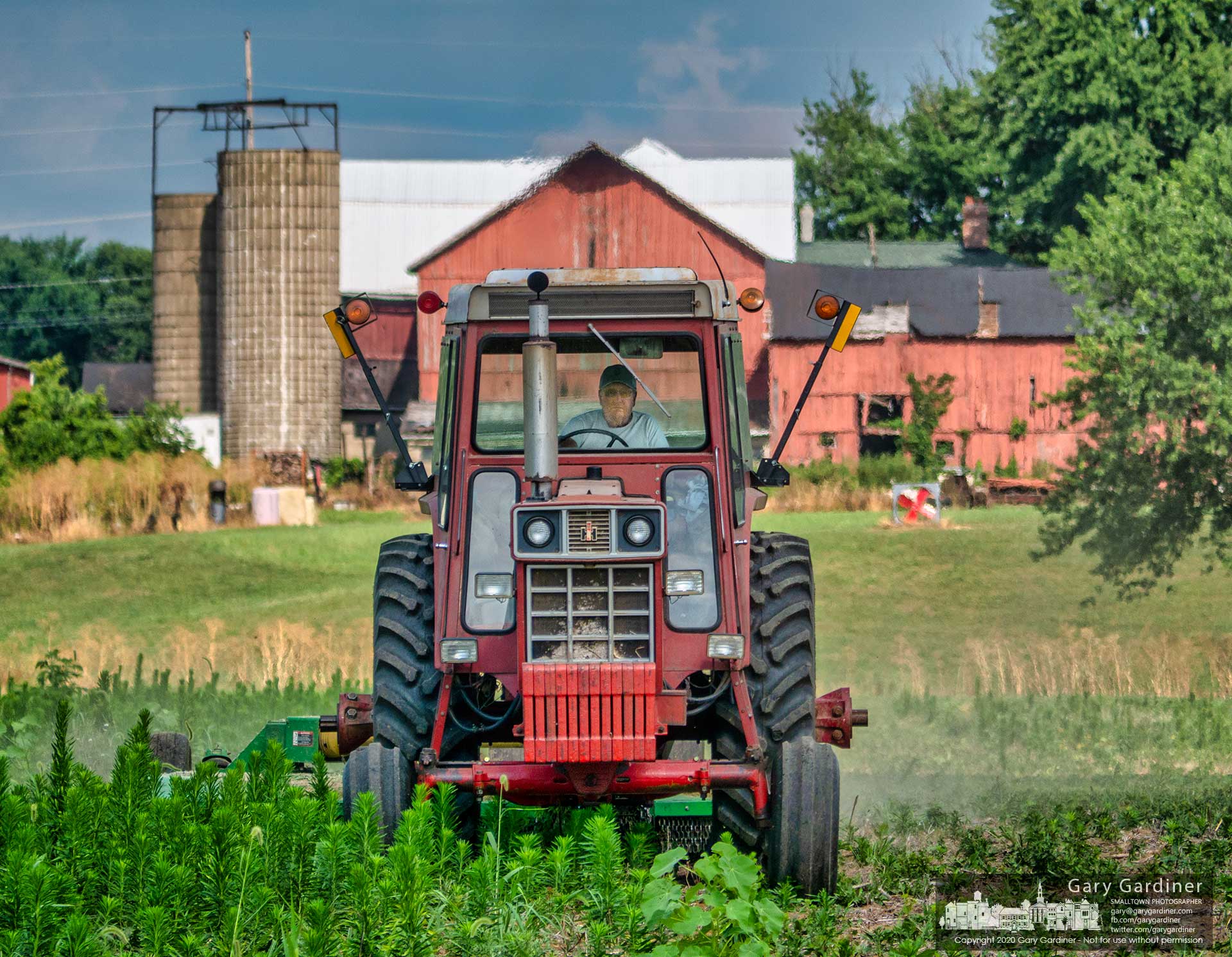 A farmer with a tractor towing a mower cuts weeds and grass in the lower field of the Yarnell Farm between Cleveland and Africa Road. My Final Photo for July 24.
