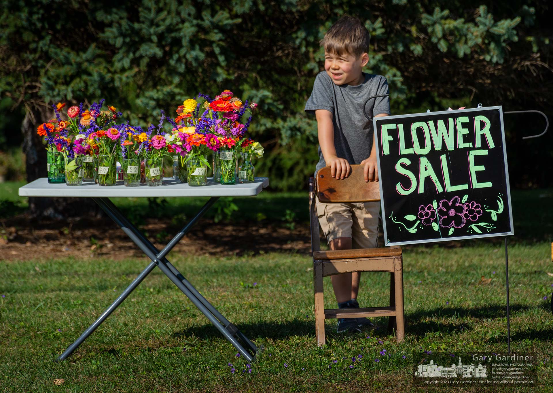 Six-year-old Clayton waits patiently for the next customer at his roadside florist shop in the front yard of his grandmother's home on East College. My Final Photo for Oct. 7, 2020.