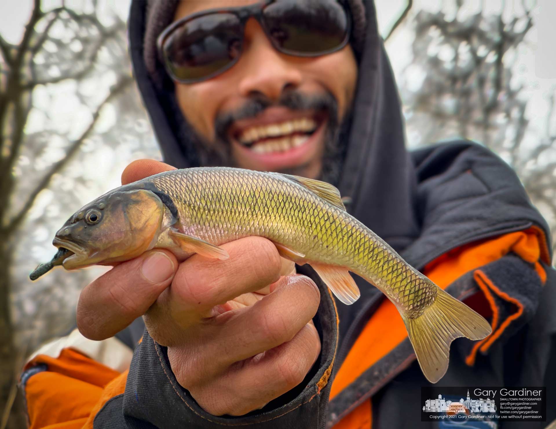 A fisherman smiles as he holds up the hand-sized creek chad he pulled from a holding pond near an office complex as his first fish of the year. My Final Photo for Jan. 8, 2021.