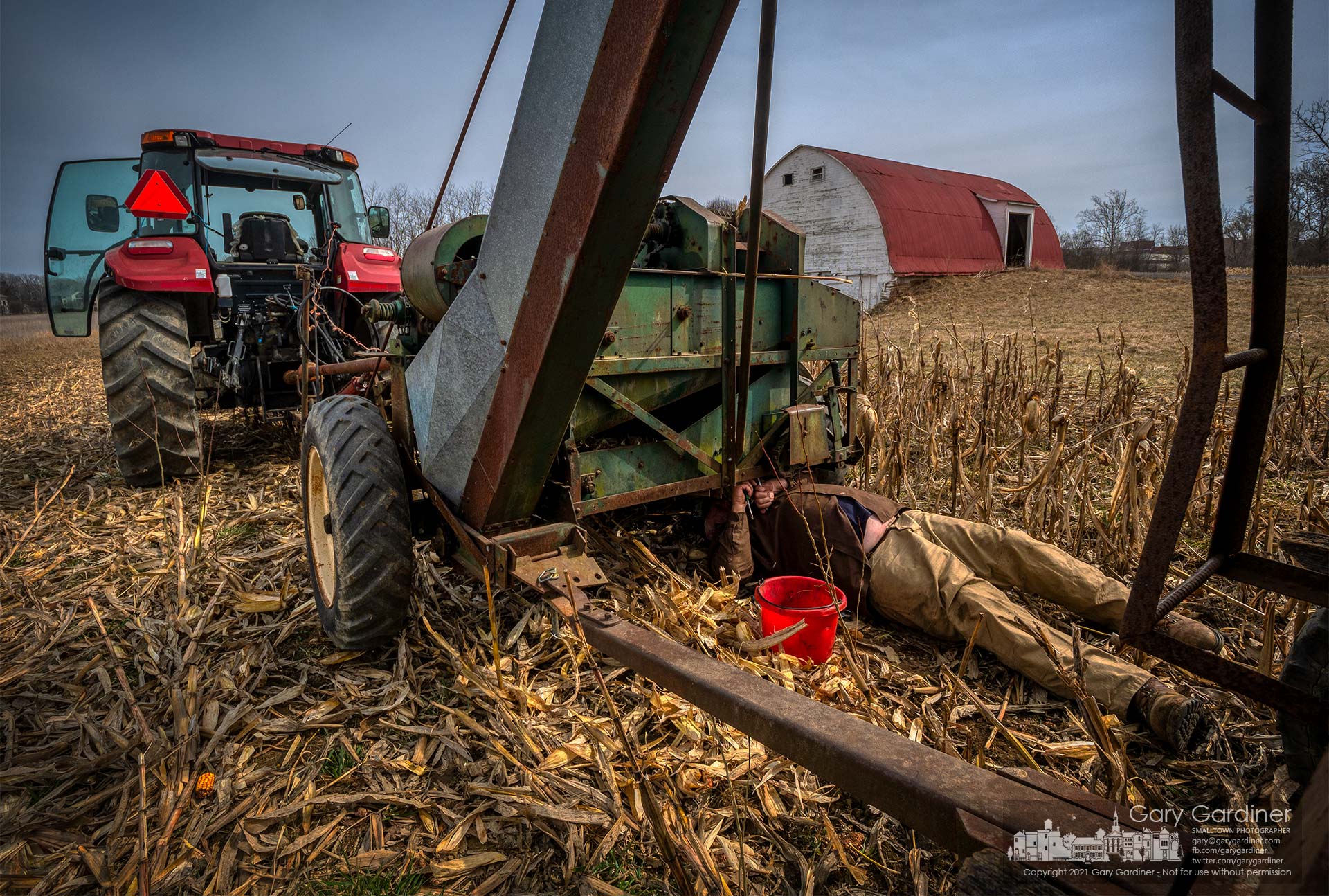 Kevin Scott repairs a broken chain drive on his one-row corn picker as he attempts to complete harvesting corn on the Braun Farm. My Final Photo for March 9, 2021.