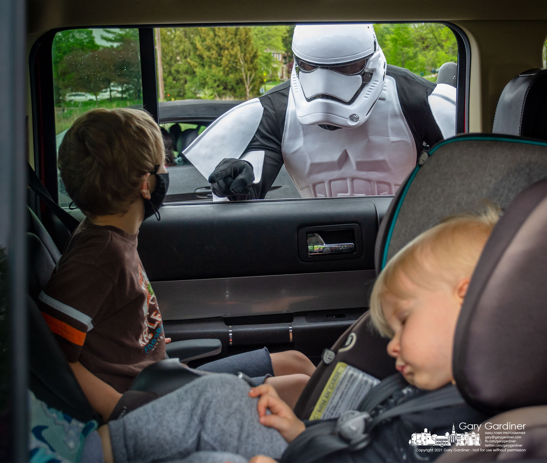 While an Imperial Stormtrooper interrogates a backseat passenger about missing droids the second passenger elects to sleep through the May the 4th food drive-thru at Highlands benefiting WARM. My Final Photo for May 4, 2021.