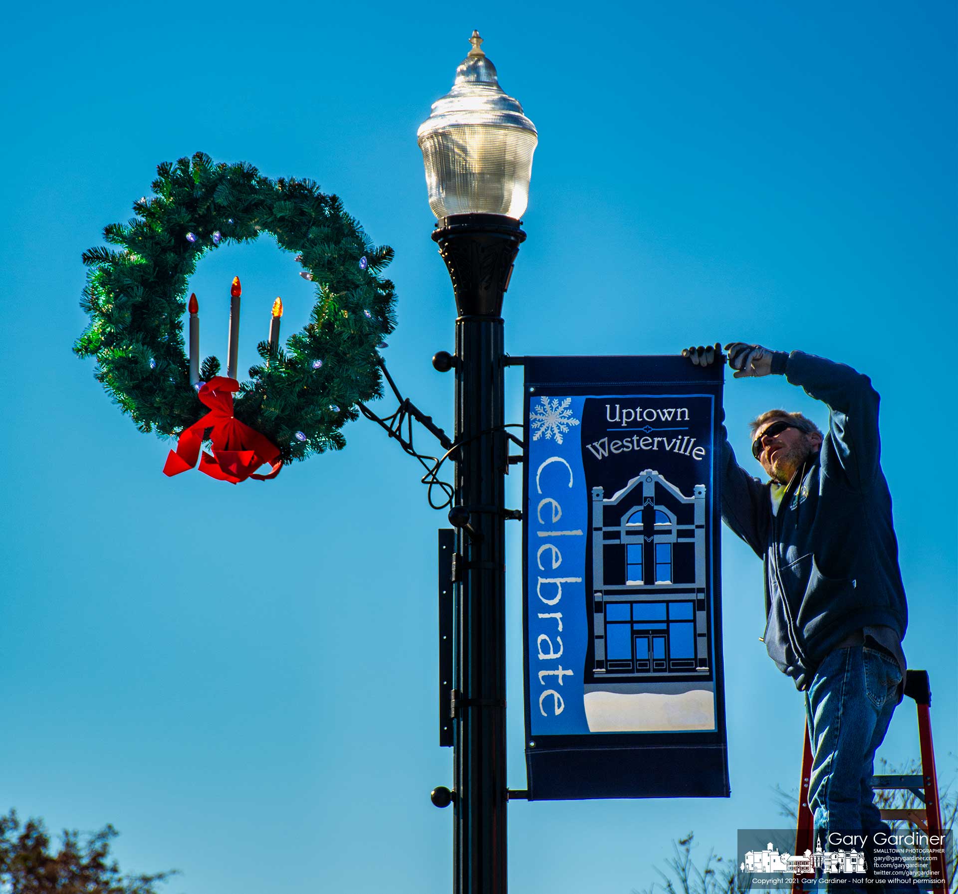 City electric workers install wreaths and holiday banners on streetlights in Uptown Westerville preparing the city for Friday's tree lighting ceremony. My Final Photo for Nov. 30, 2021.