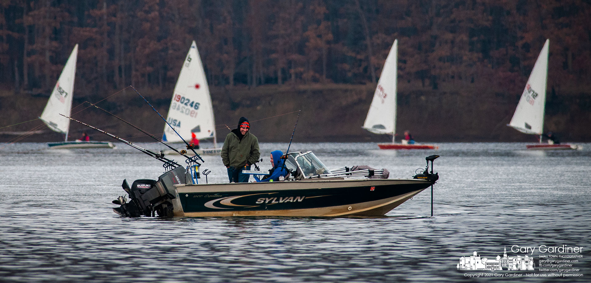 A pair of fishermen enjoy a laugh as Laser sailors from the Hoover Sailing Club share the calm waters of Hoover Reservoir on the final day of 2021. By Final Photo for Dec. 31, 2021.