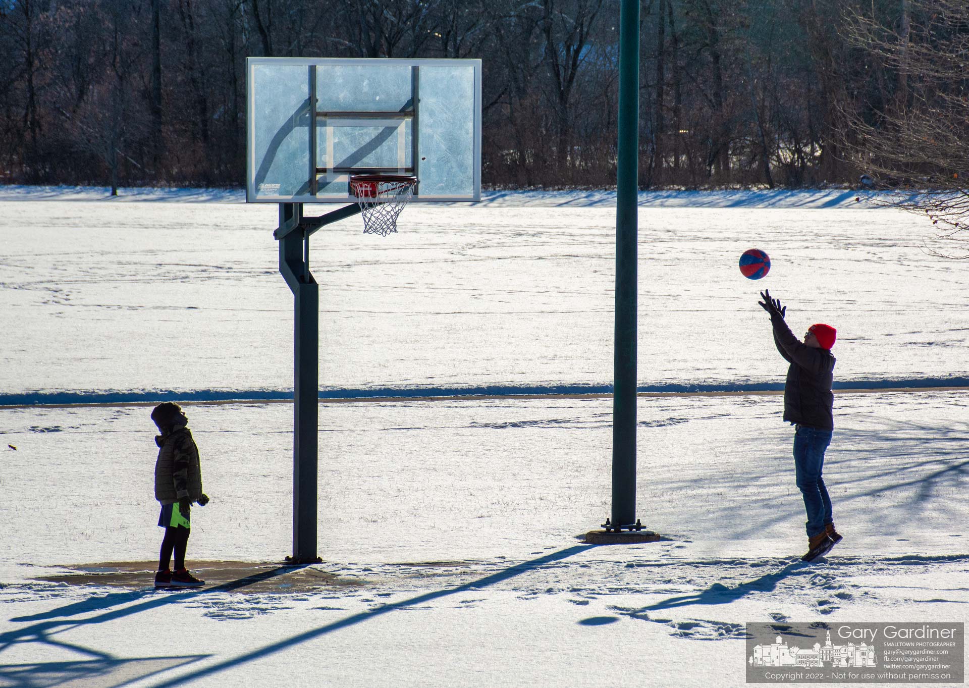 Father and son hold a shoot-around on the snow covering the basketball courts at the Westerville Sports Complex. My Final Photo for Jan. 19, 2022.