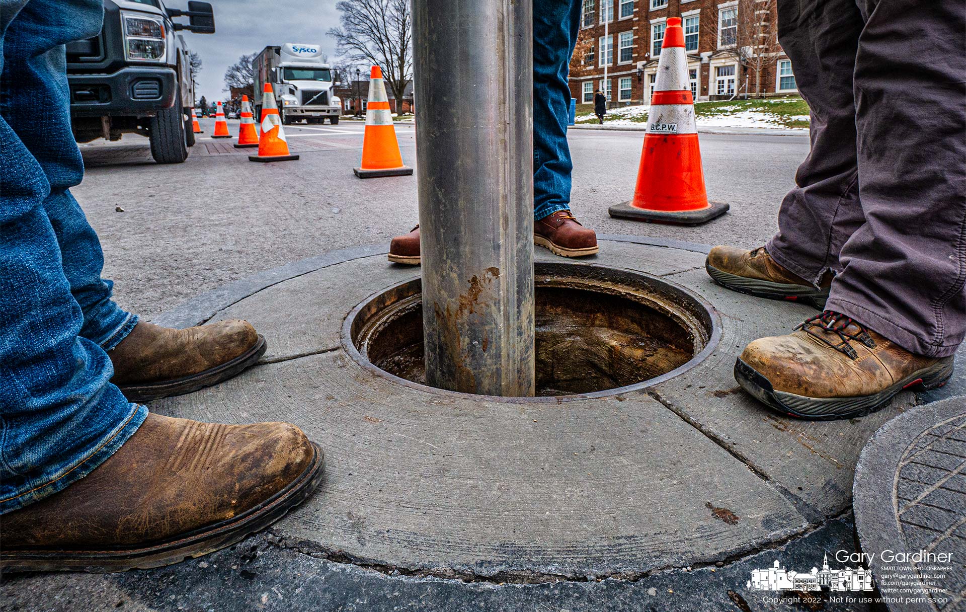 A city work crew vacuums debris and obstructions from beneath a storm sewer manhole cover at State and Park Streets. My Final Photo for Jan. 20, 2022.
