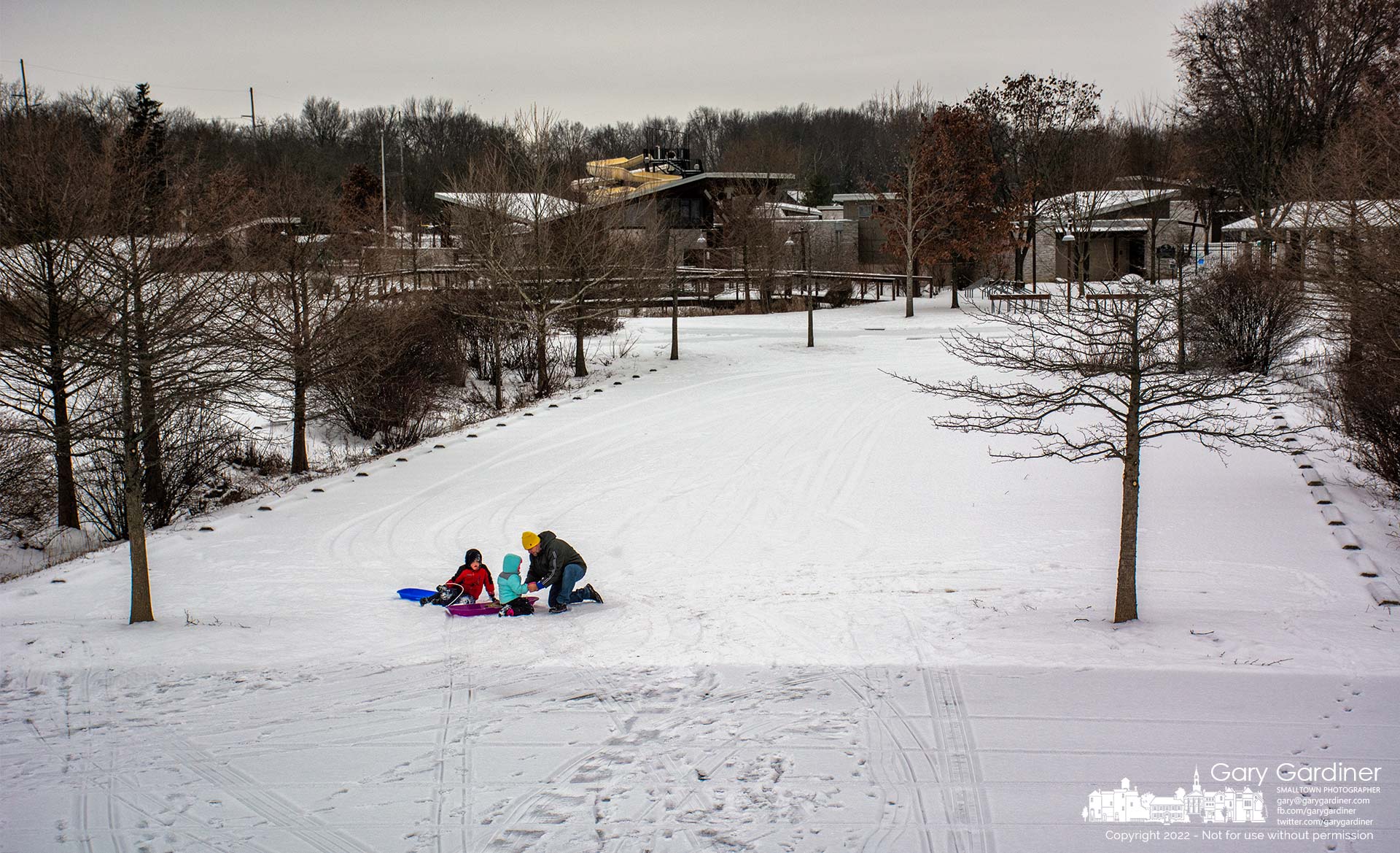 A father returns his daughter's gloves to her hands after they came off during a speedy trip down the ice-covered small sledding hill at Highlands Park. My Final Photo for Jan. 28, 2022.
