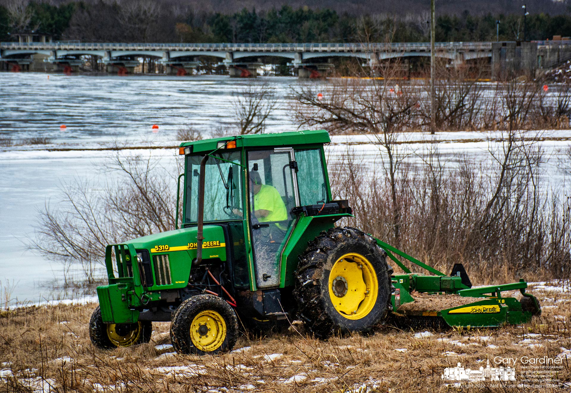 A work crew cuts the prairie grasses and plants along the shoreline of Hoover Reservoir near the dam completing a large portion of clearing dried vegetation from near the lake. My Final Photo for Feb. 11, 2022.