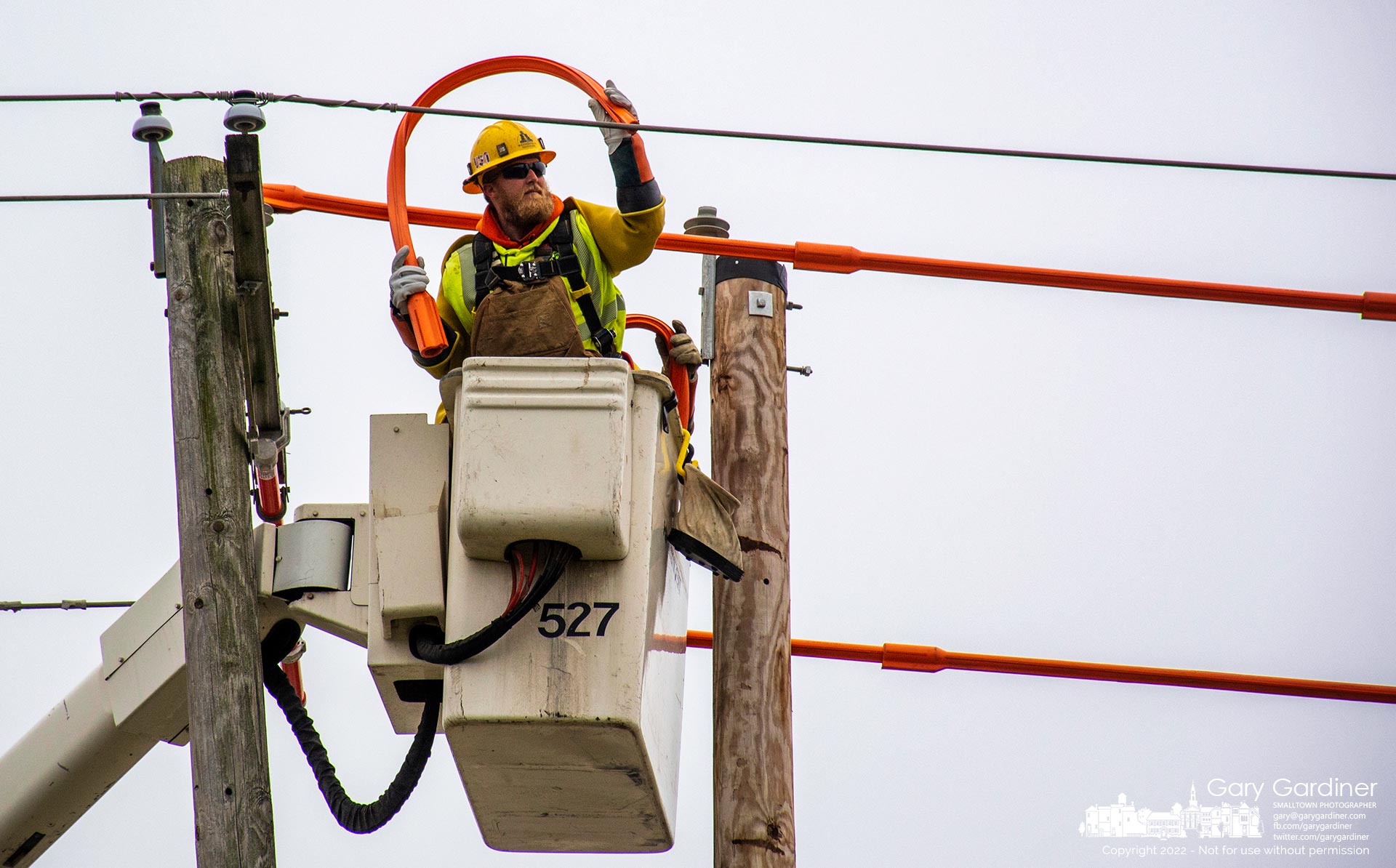 A city linesman twists a cable insulator making it easier to wrap one of the powerlines being transferred to a cross-member that will be installed on a replacement utility pole at Schrock and Cooper Roads. My Final Photo for Feb. 23, 2022.