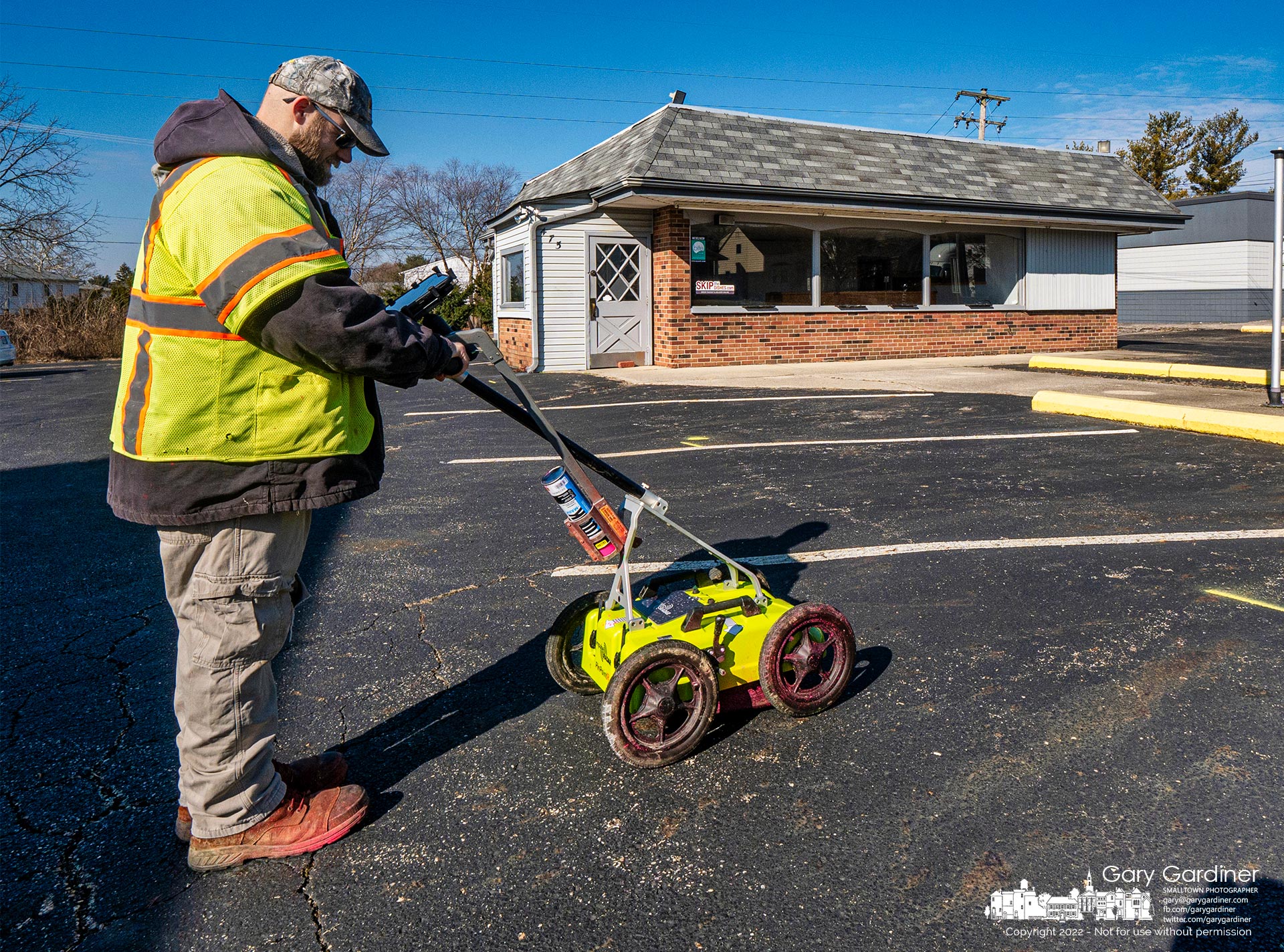 A surveyor checks data after using ground-penetrating radar to locate and catalog underground utilities at the old Yogi's Hoagies and two other buildings on South State that will be demolished to make way for a drive-thru Dunkin' donut store. My Final Photo for Feb. 28, 2022.