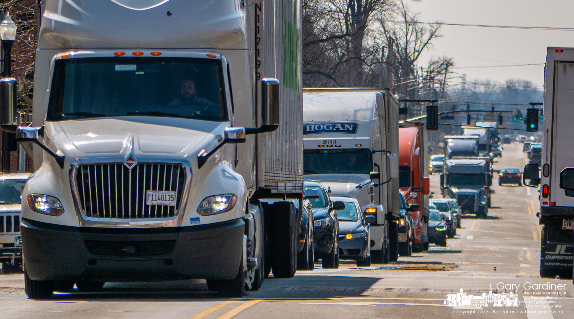 A line of long-haul trucks and semi-truck trailers snake their way on 3C Highway through Uptown Westerville after being diverted from I-71 after it was closed following a shooting. My Final Photo for March 11, 2022.
