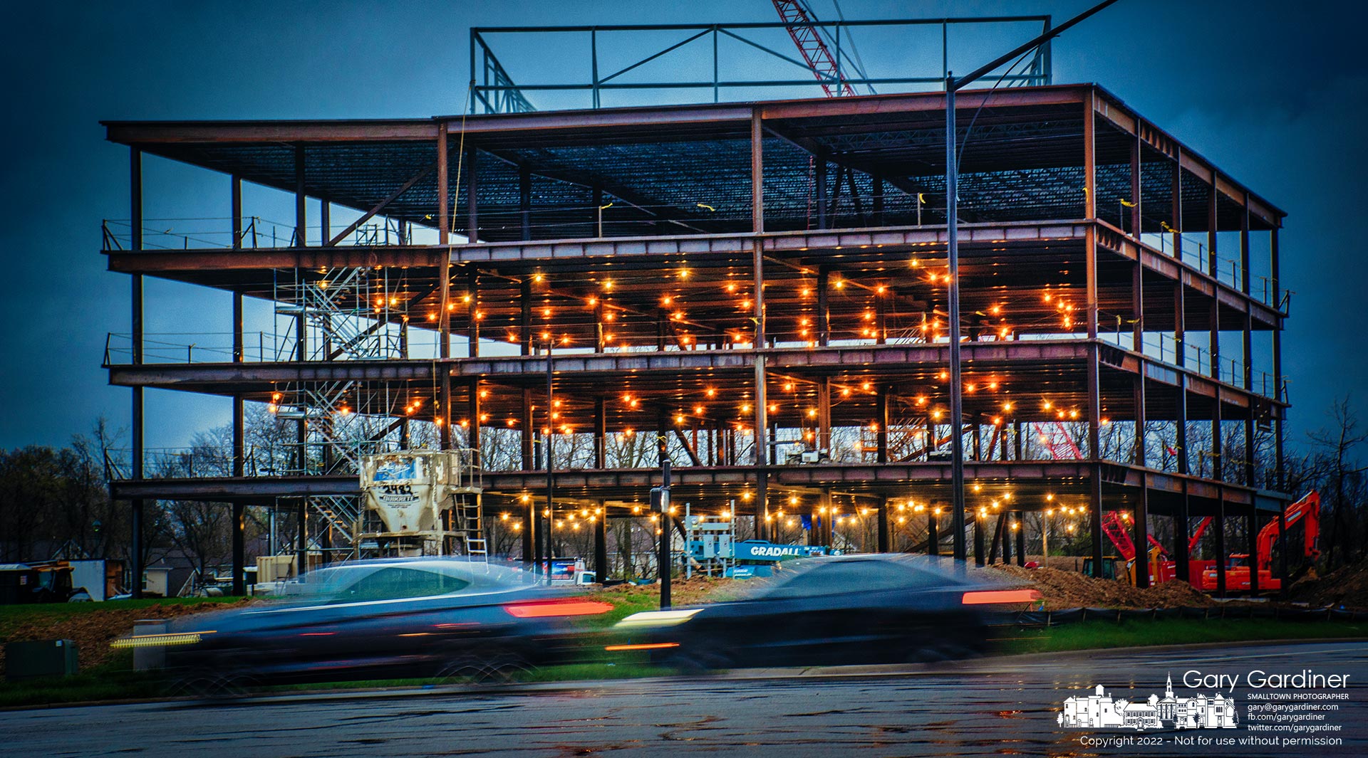 Early morning commuters pass the Orthopedic One offices a few minutes after sunrise when the steel structure is still lit by lights left on overnight to act as security lights. My Final Photo for April 14, 2022.