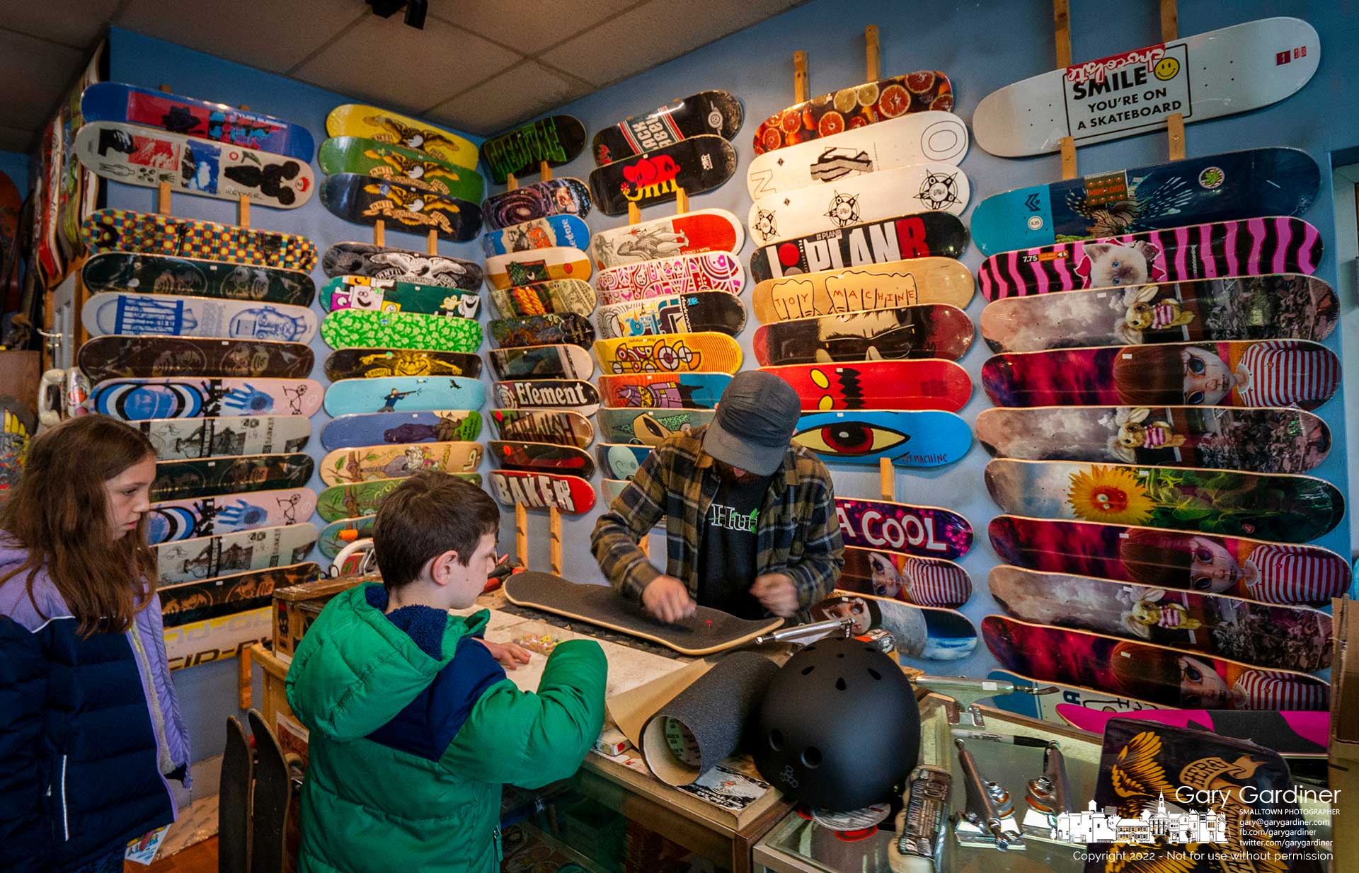 A brother and sister watch as their new skateboards are built after selecting them from the wall of boards at Old Skool Skate Shop in Uptown Westerville. My Final Photo for April 9, 2022.