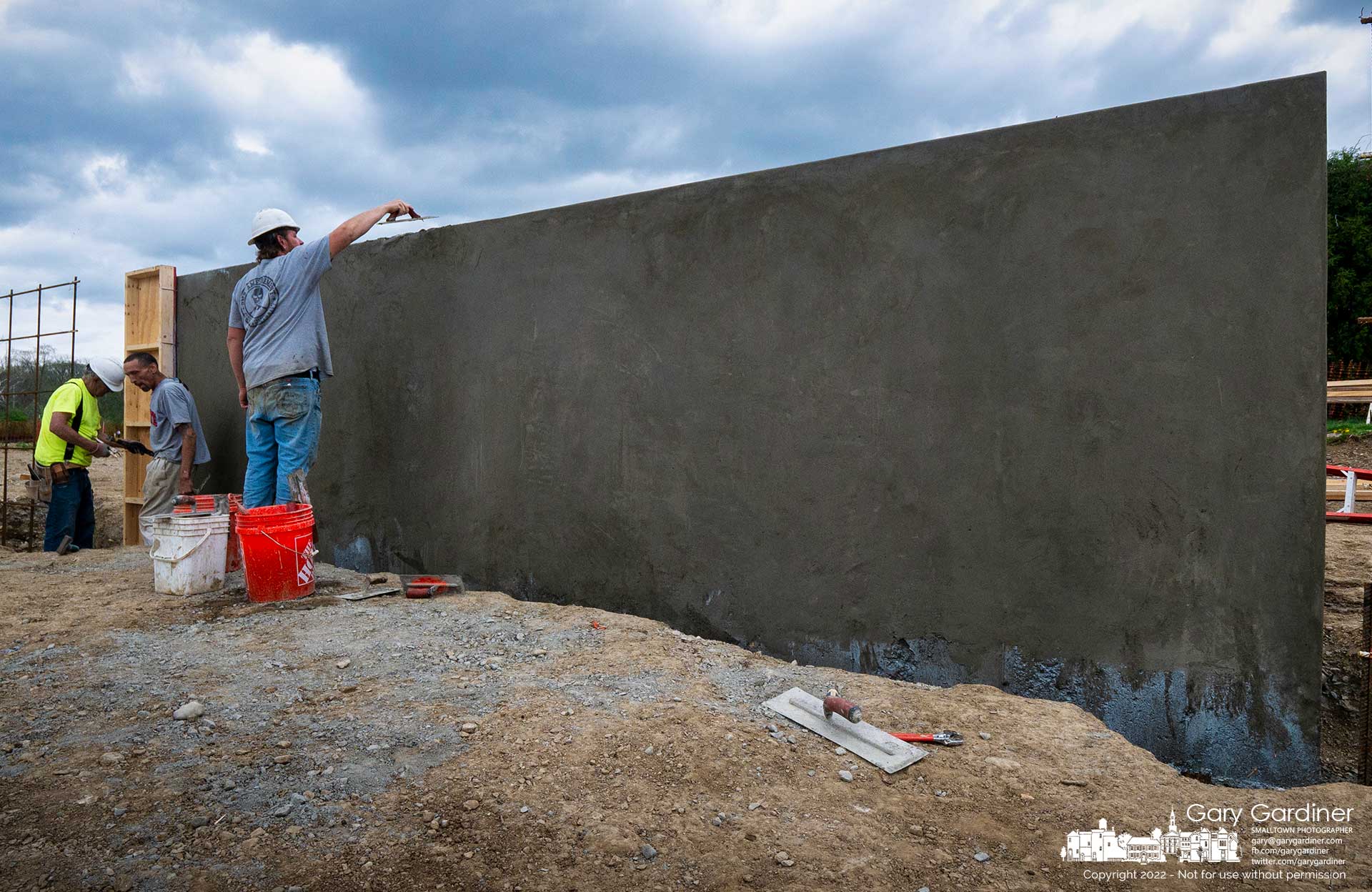 A worker applies stucco to a concrete poured wall, one of the first sections built for the Veterans Memorial at the Westerville Sports field across from the Community Center. My Final Photo for April 25, 2022.
