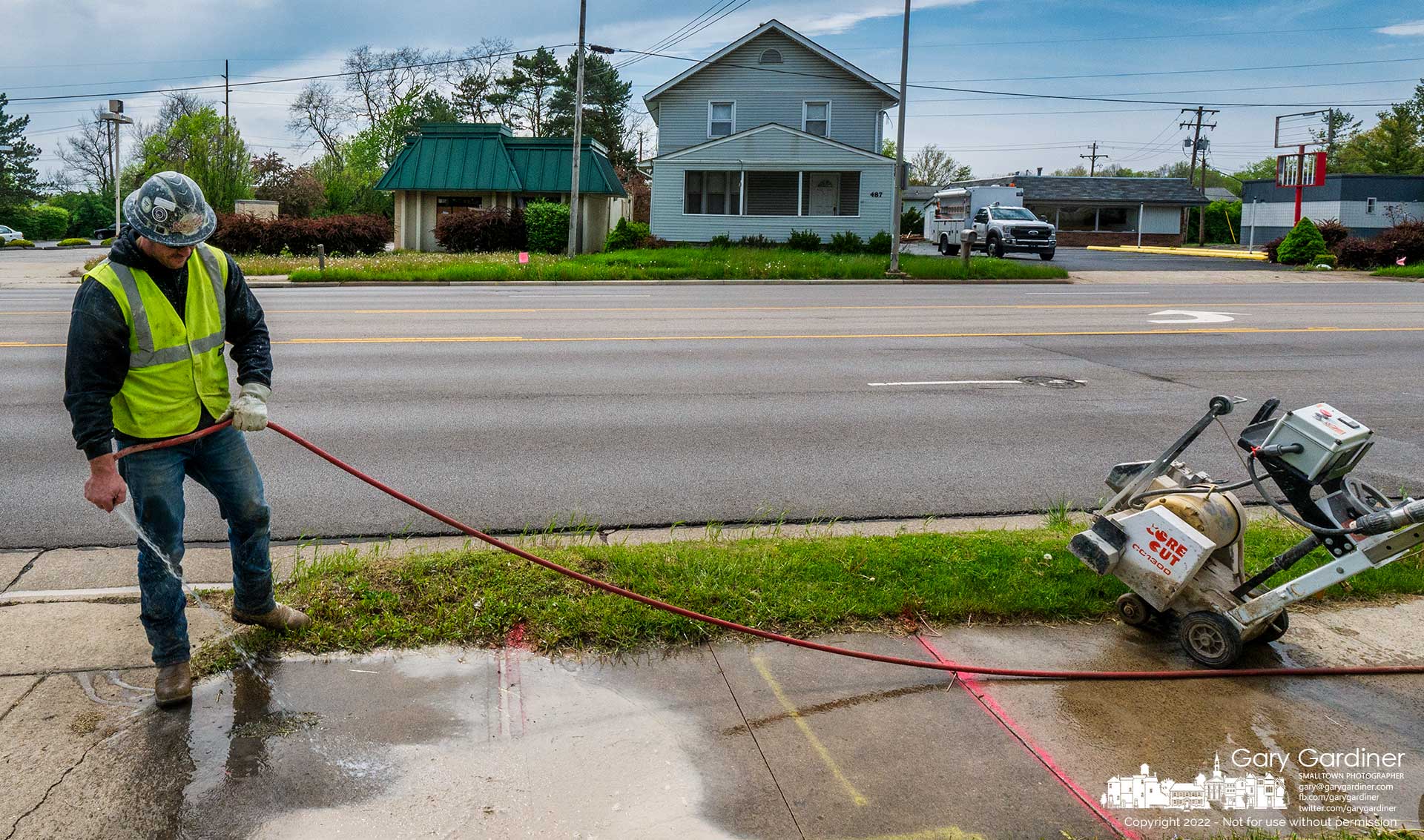 A worker cleans away wet concrete dust created when he cut sections of the sidewalk where Columbia Gas will disconnect three buildings across the street to make way for a Dunkin doughnut drive-thru restaurant. My Final Photo for May 3, 2022.