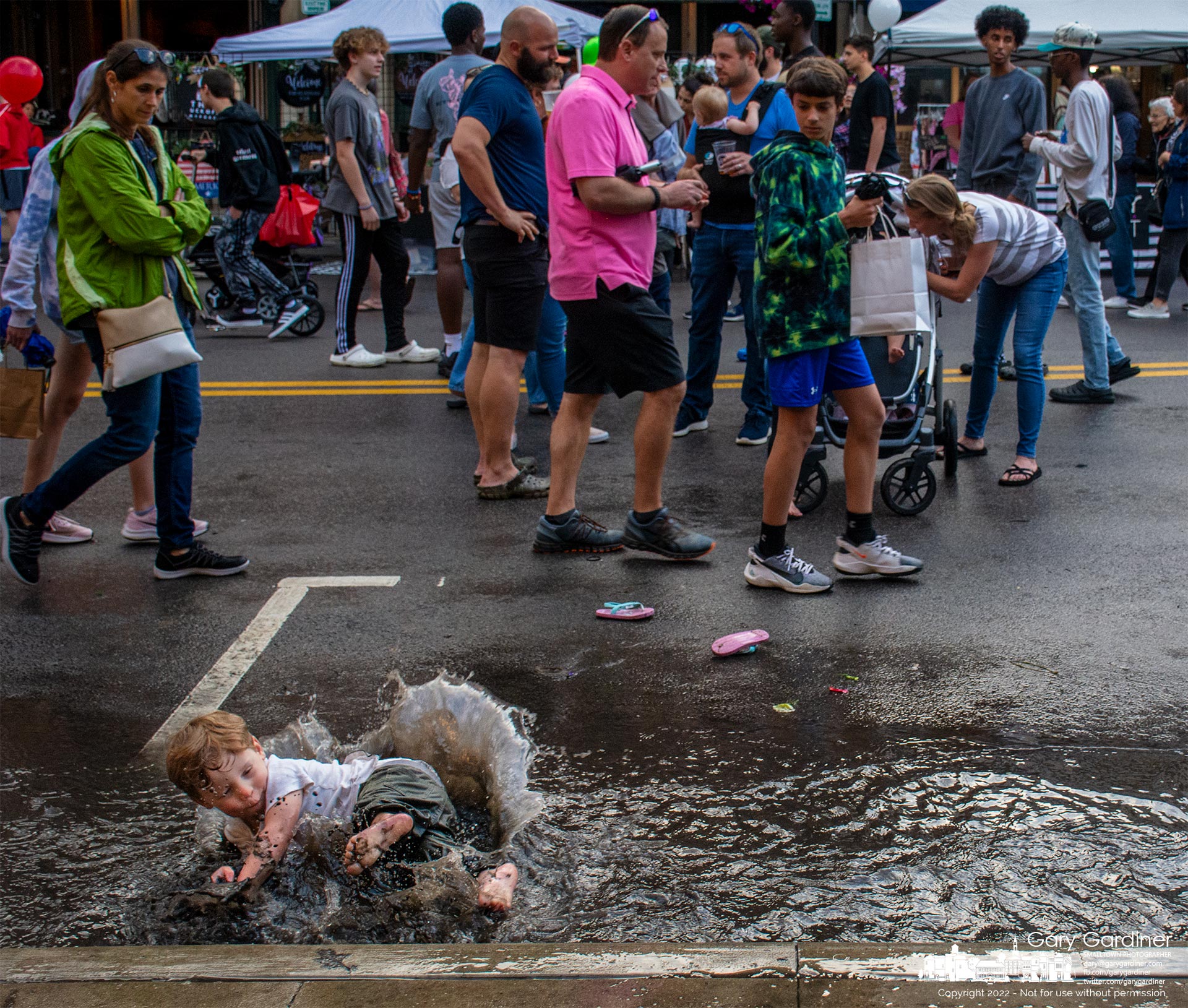 A youngster falls into the puddle he and two of his friends had been running through after a brief rain during Fourth Friday in Uptown Westerville. My Final Photo for May 27, 2022.