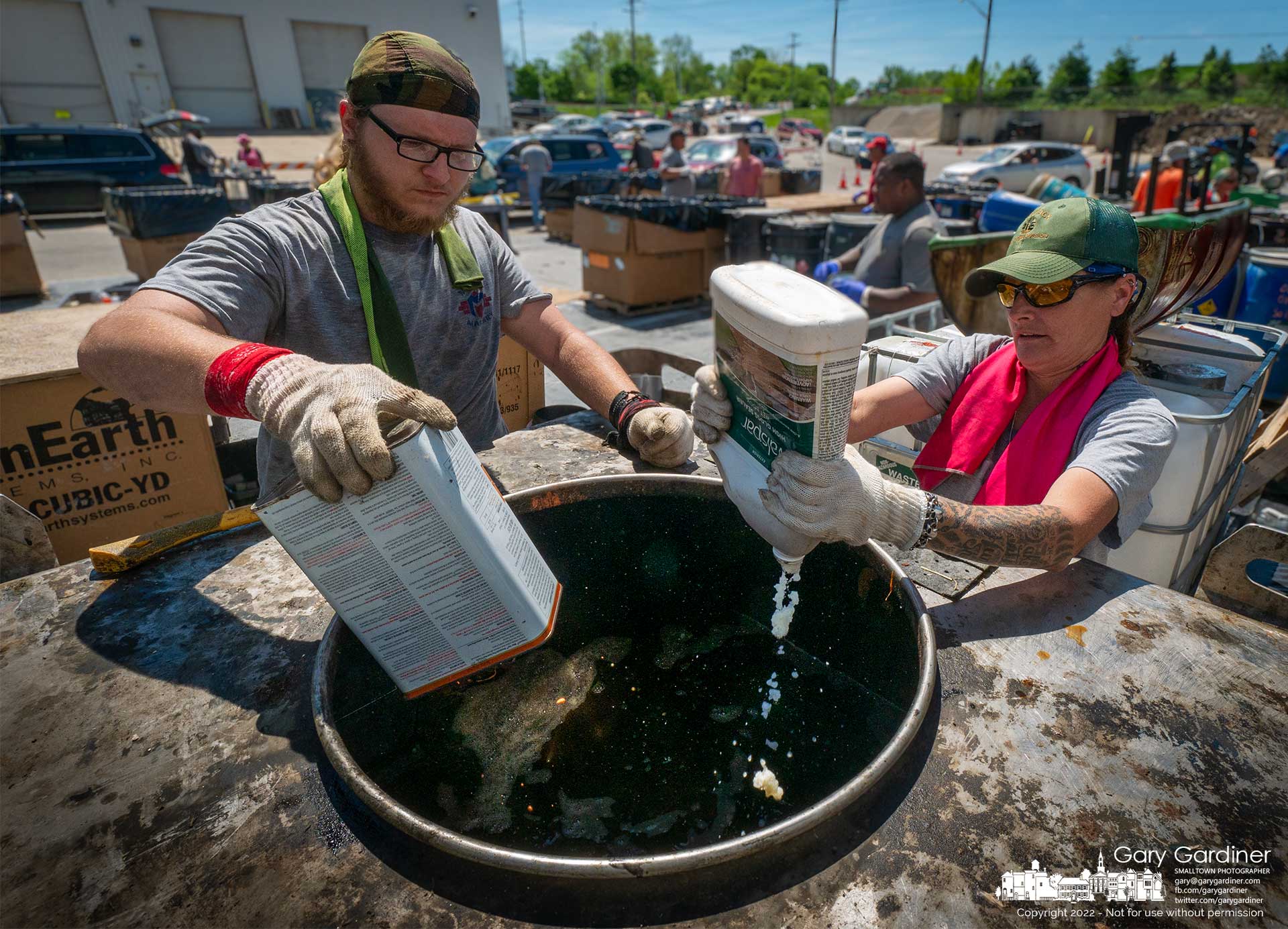 Containers of volatile petroleum products are poured into a holding tank for disposal as part of the collection of household hazardous waste at the city garage Saturday. My Final Photo for May 14, 2022.