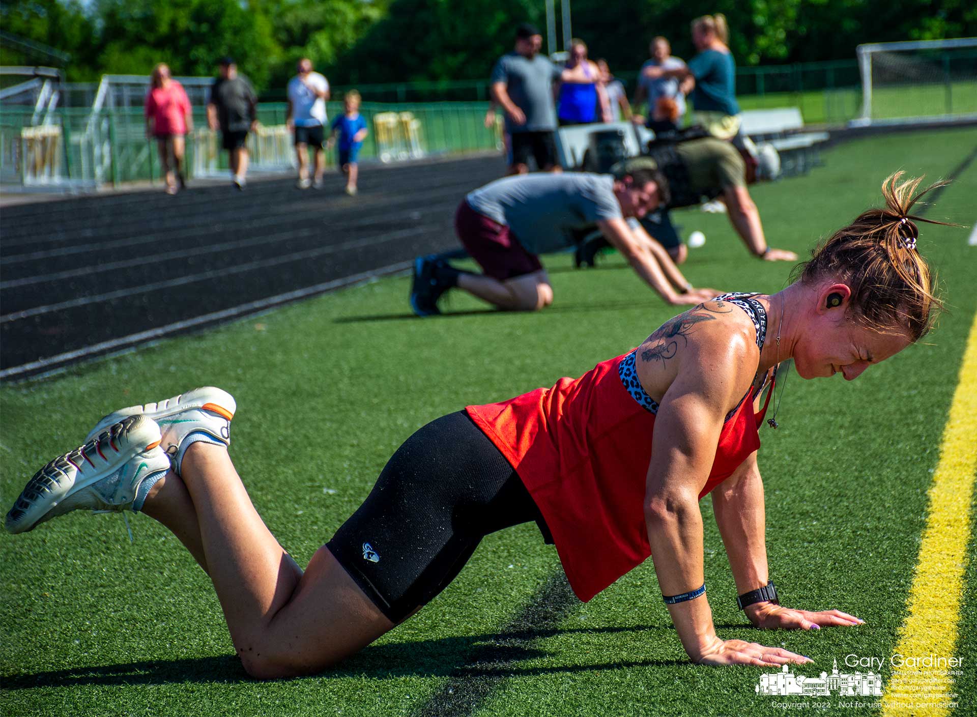 A woman struggles against exhaustion to complete a set of pushups after her 8 laps around the Westerville North High School with each lap followed by a set of squats and pushups to complete the Memorial Day Morelli scholarship fundraiser honoring Anthony P. Morelli, a Westerville police officer who was killed in the line of duty. My Final Photo for May 30, 2022.