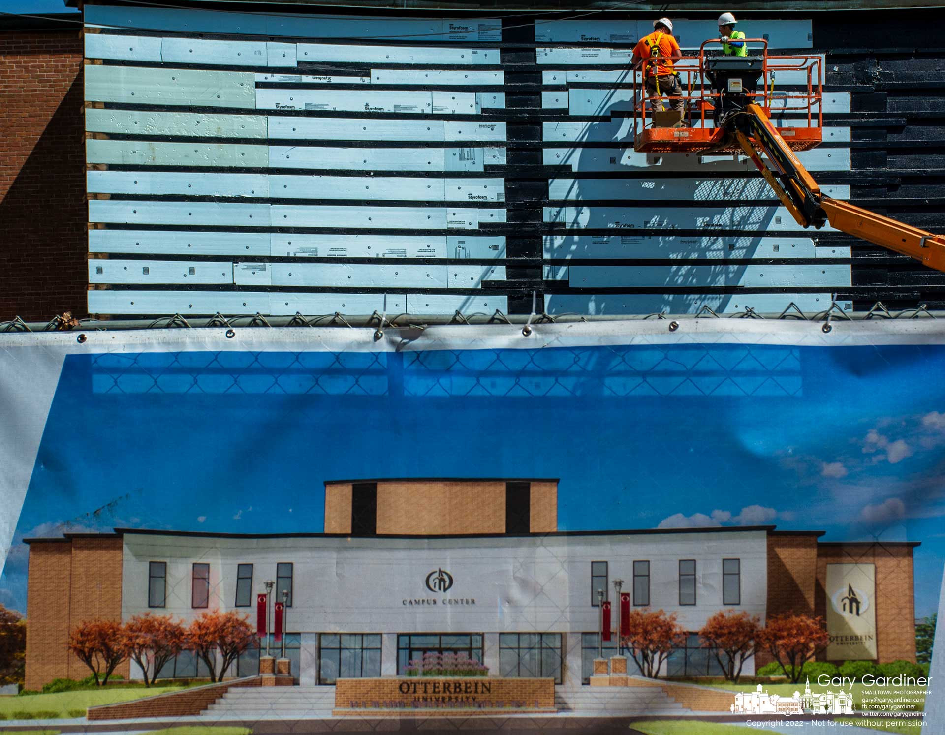 Workers apply sheathing to the facade of the student center at Otterbein University transforming the original look into a more contemporary style matching the banner that hangs on a fence at the front of the building. My Final Photo for June 28, 2022.