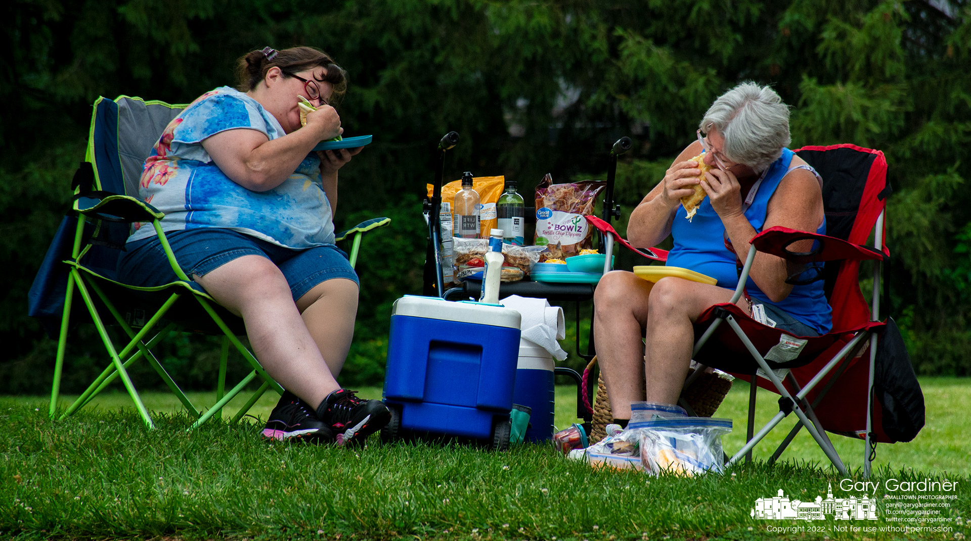 Two mothers bite into their chicken sandwiches during lunch at Alum Creek Park where they waited for their children to complete choir camp at Otterbein University. My Final Photo for June 20, 2022.