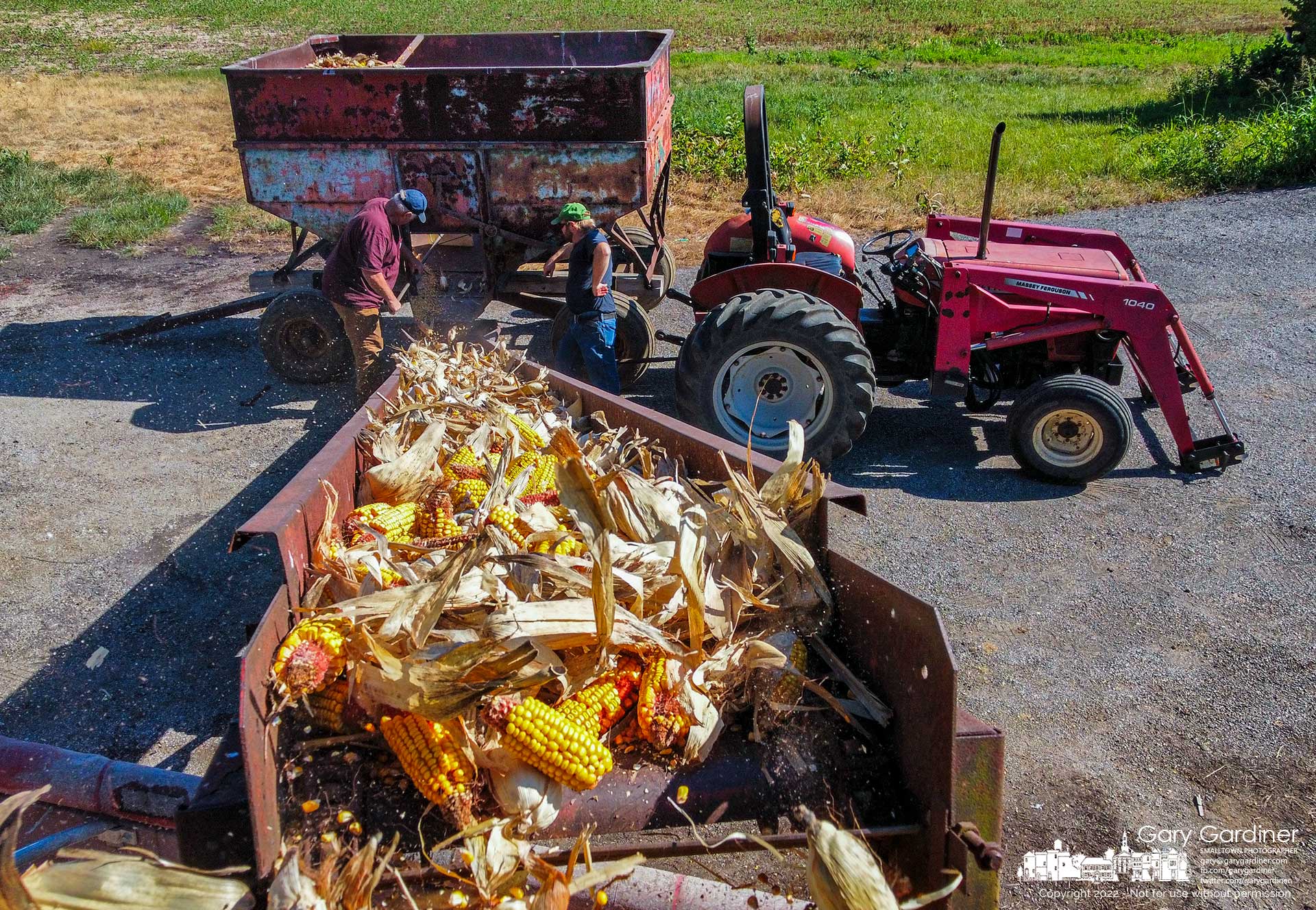 Corn is transferred from storage in a harvest wagon to a wagon for transport as farmers clear the barn at the Braun Farm preparing for another harvest. My Final Photo for July 13, 2022.