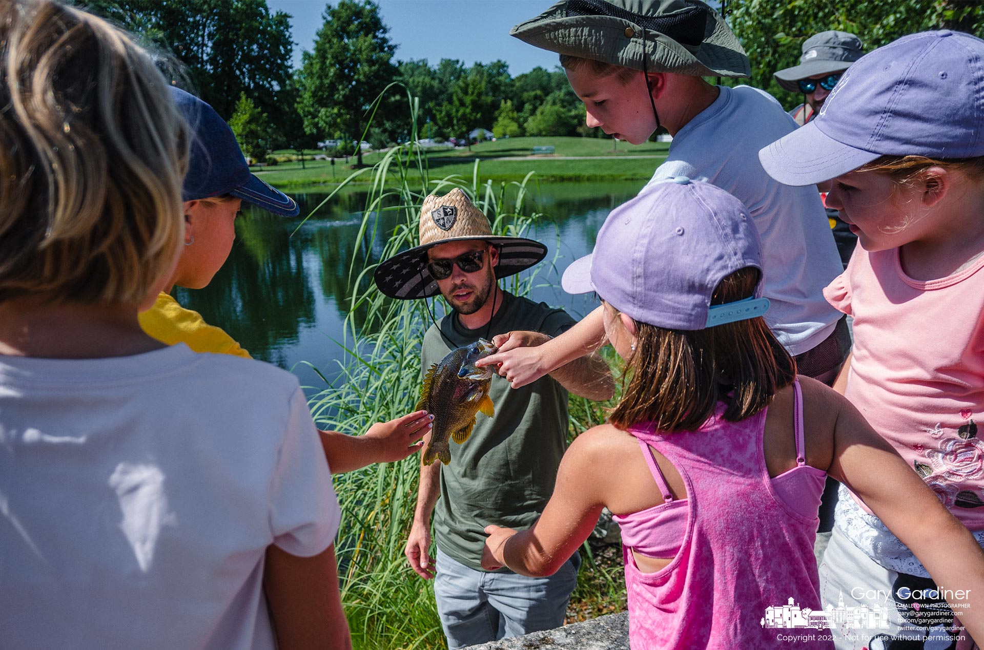 A group of young anglers reaches to touch a bluegill pulled by one of them from the pond at Heritage Park Saturday afternoon. My Final Photo for July 23, 2022.