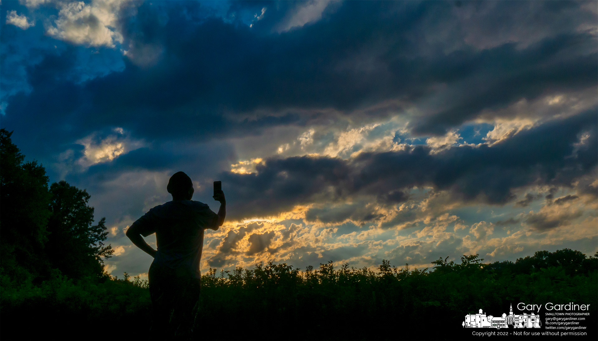 A music minister sings into her phone as she records the sunset over the prairie at Sharon Woods Metro Park. My Final Photo for July 29, 2022.