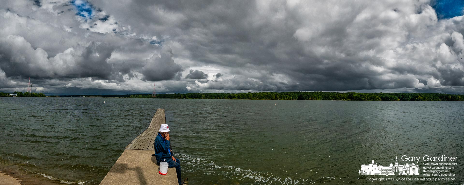 A fisherman smokes a cigarette as he tends to two lines cast from the Walnut Street boat ramp into Hoover Reservoir as storm clouds darken the horizon at the reservoir. My Final Photo for Sept. 6, 2022.