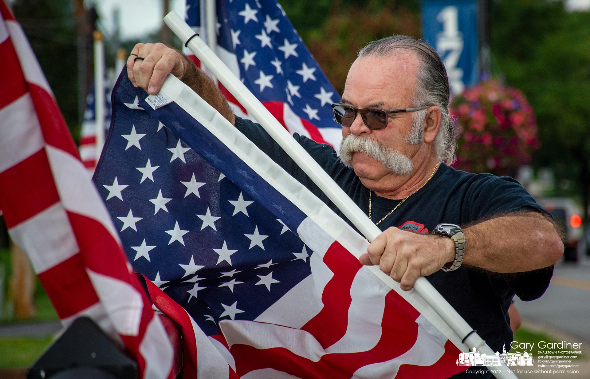 Retired Westerville firefighter Tom Ullom repairs the fasteners on a flag before attaching it to the Main Street bridge near First Responders Park for the city's observance of 9/11 and the terrorist attack on the World Trade Center. My Final Photo for Sept. 8, 2022.