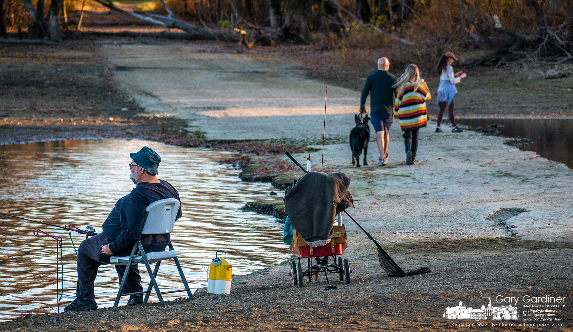 A fisherman watches his lines thrown into Hoover Reservoir as people walk across an exposed section of the old Sunbury Road that is usually covered by water from the reservoir. My Final Photo for October 29,2022.