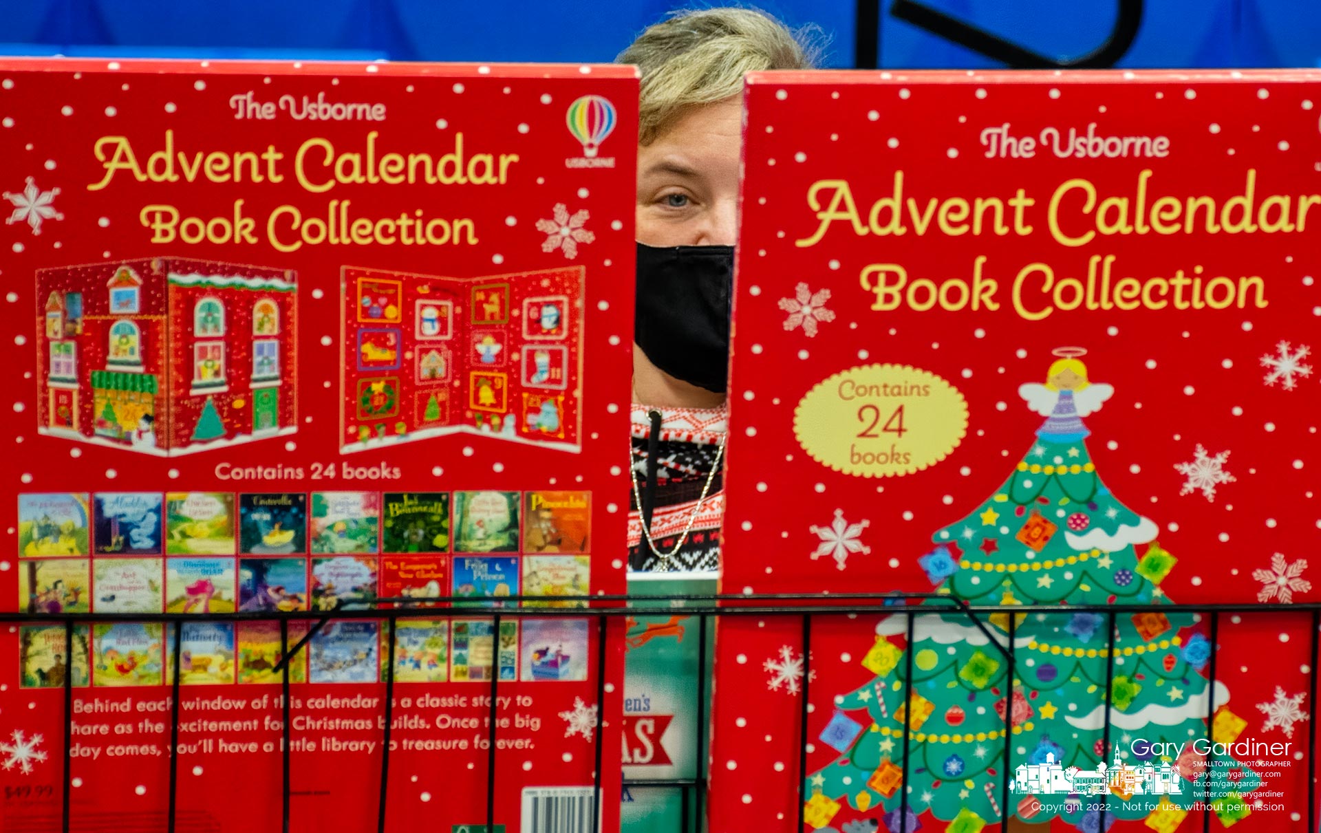 A woman studies a selection of books and calendars while pondering a purchase at the Christmas bazaar at St. Paul the Apostle Catholic Church on Saturday afternoon. My Final Photo for November 20, 2022.