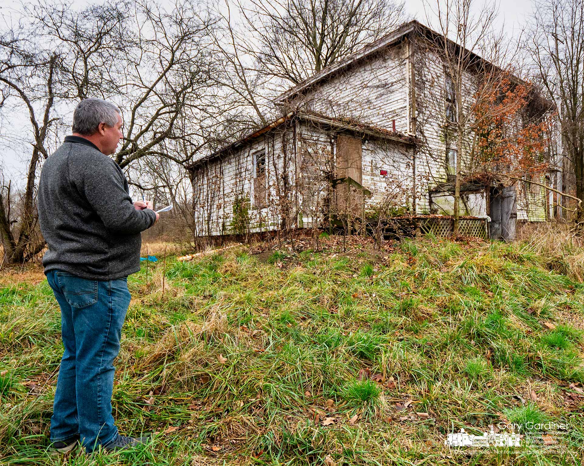 A demolition company worker figures how many truckloads of material will be hauled away when the farmhouse at the Braun Farm is demolished as the new owner plans to develop the property. My Final Photo for November 28, 2022.