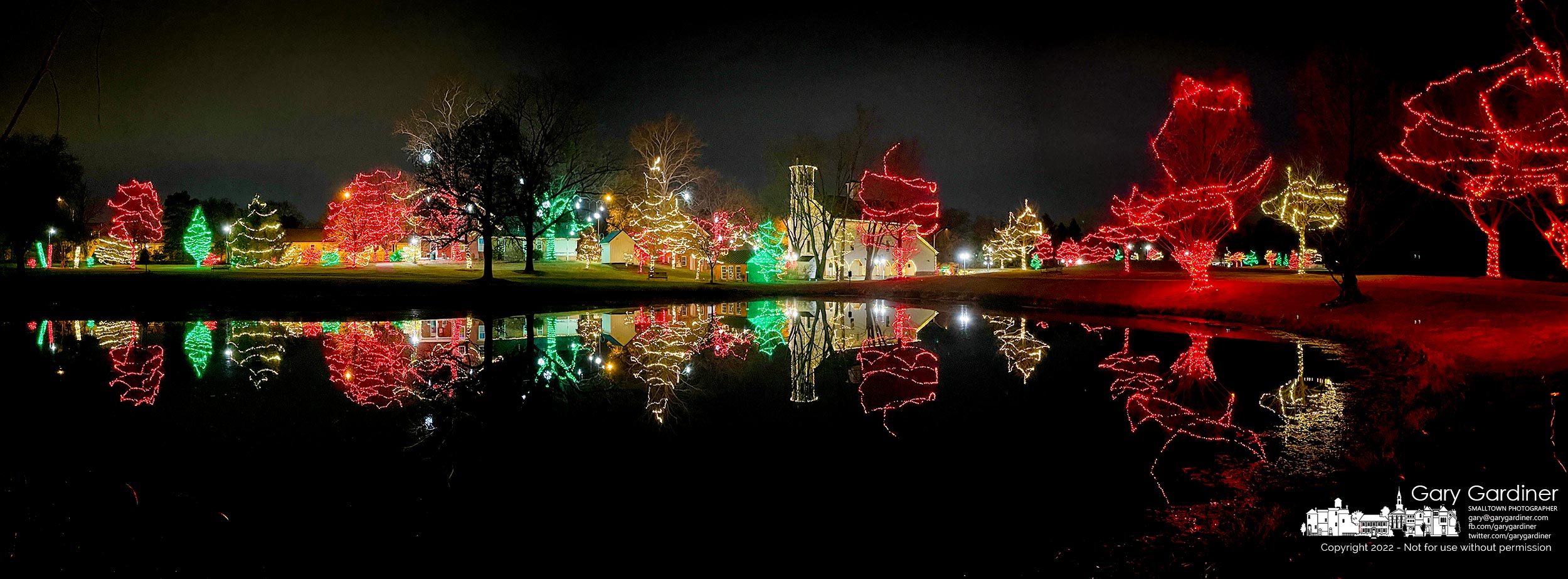 Holiday lights reflect in the pond at Heritage Park on Thanksgiving night as the city prepares the park for the holiday season and Snowflake Castle in the Everal Barn starting Monday. My Final Photo for November 24, 2022.