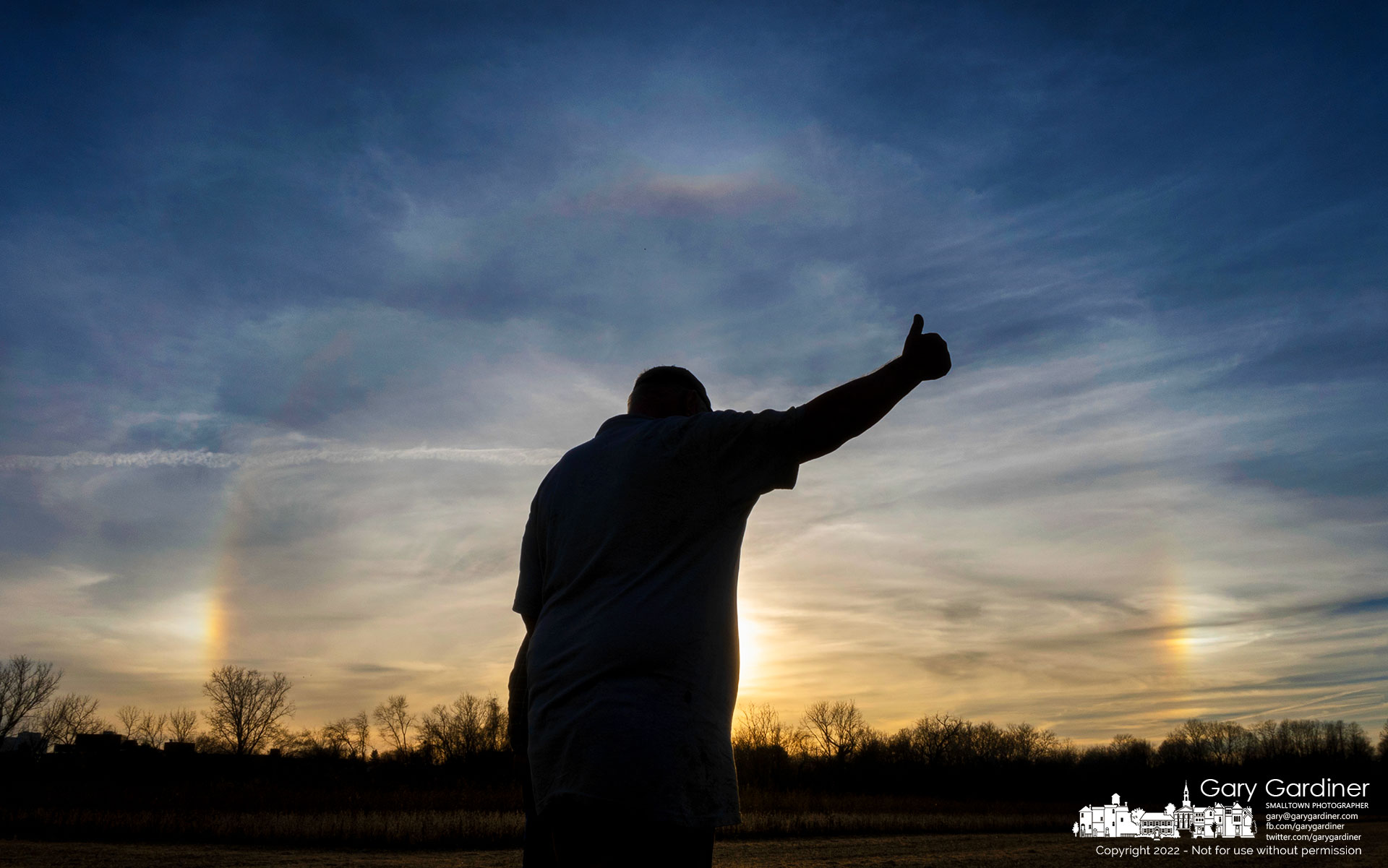 Kevin Scott is silhouetted against sun dogs as he signals a lift operator instructions to move repair parts into position to fix the broken combine on the Braun Farm. My Final Photo for November 10, 2022.