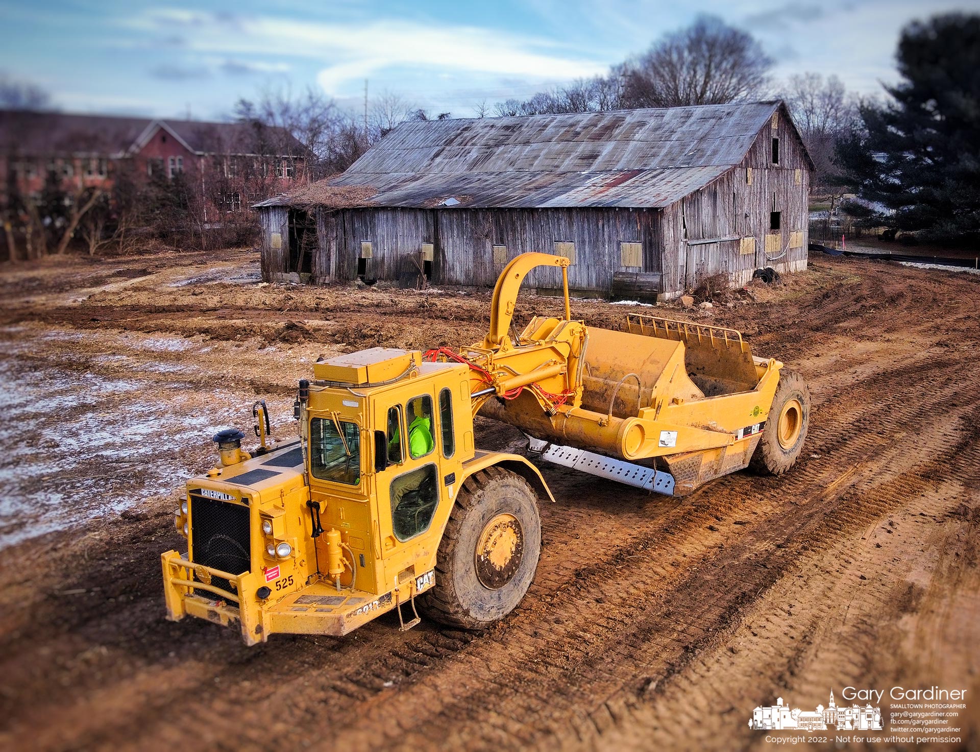 An earthmover travels past the abandoned and empty barn of a former farm on Africa Road where developers are building townhomes on the land including where the barn will soon be demolished. My Final Photo for December 19, 2022.