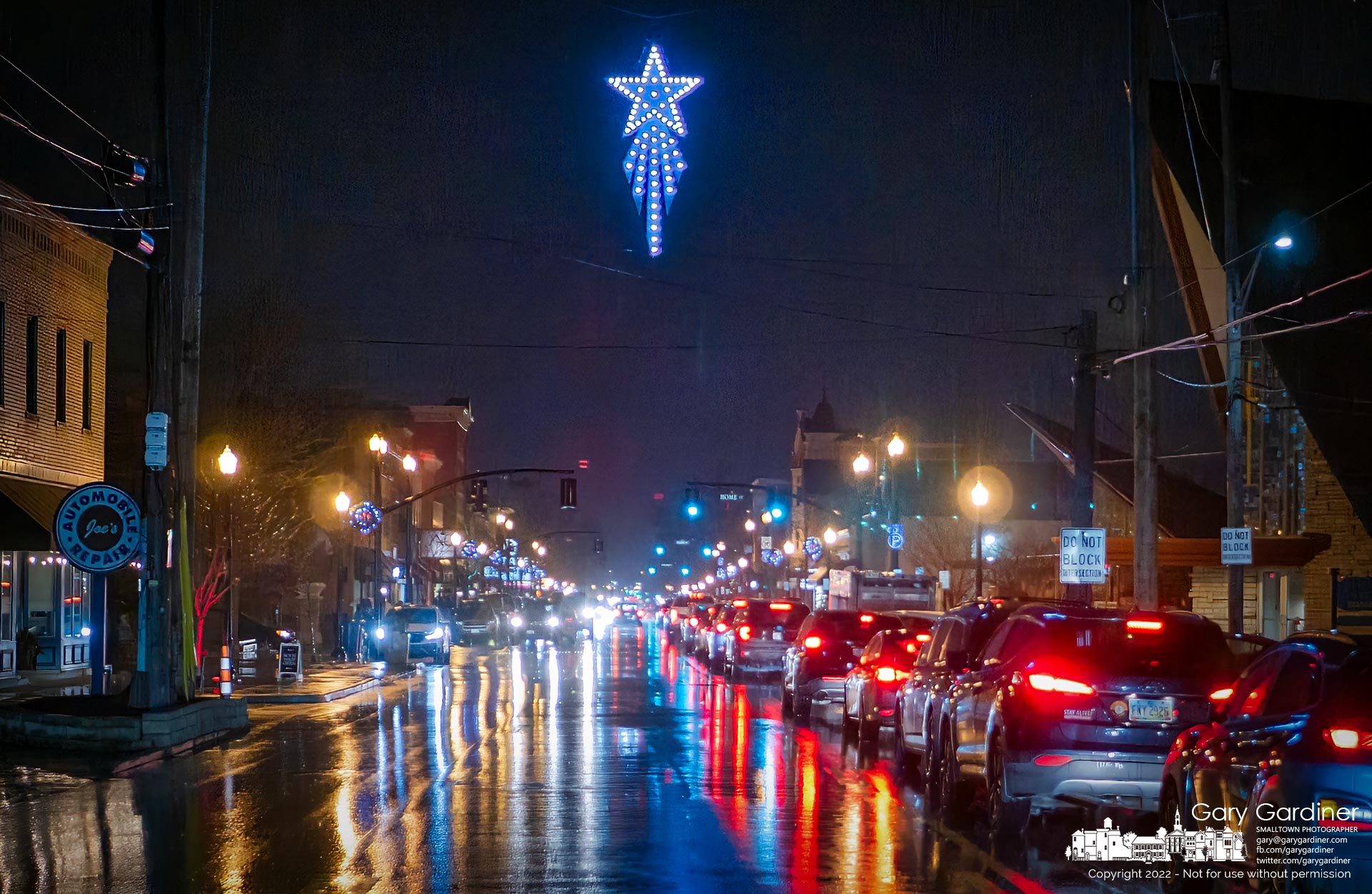 Shopper's and commuter's car lights reflect in the rain-slick streets of Uptown Westerville where the city's Holiday Star shines bright on a Friday night. My Final Photo for December 9, 2022.