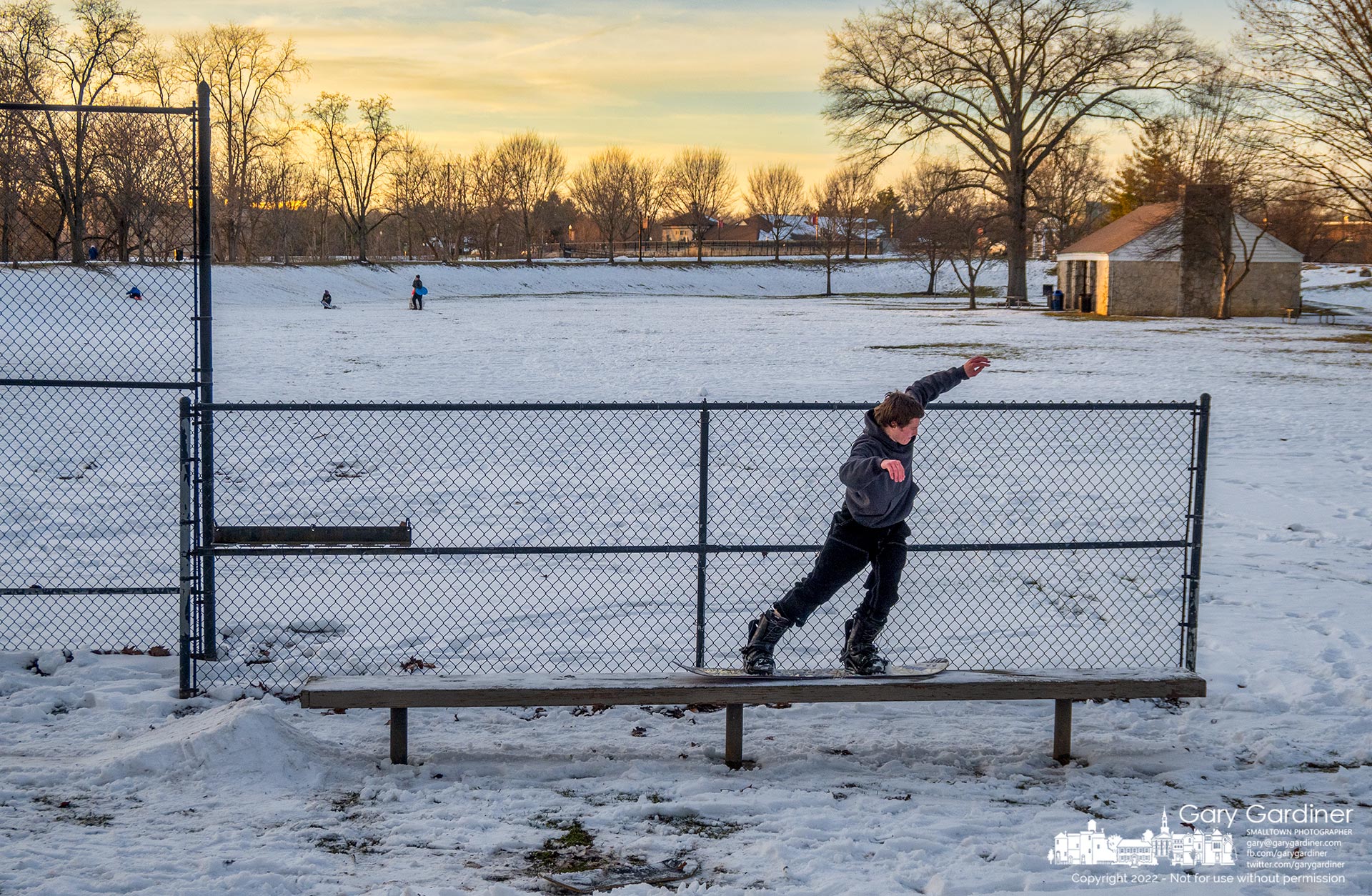 A snowboarder steadies himself as he nears the end of a ride across the player's bench at Alum Creek Park where he and another boarder built ice ramps to propel themselves across the bench usually empty this time of the year. My Final Photo for December 28, 2022.