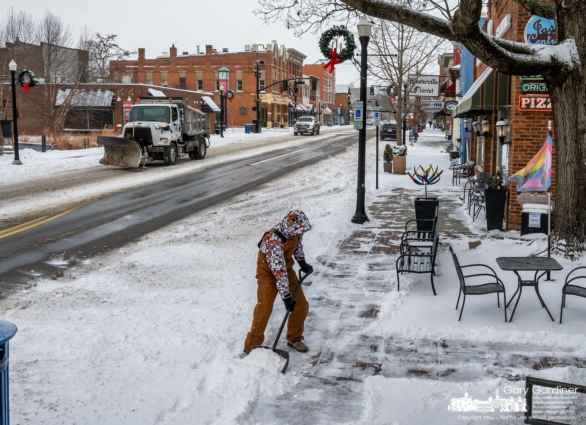 A Westerville city snow plow passes a man shoveling snow in front of Java Central after an overnight storm left several inches of snow and temperatures that dropped almost 50 degrees. My Final Photo for December 23, 2022.