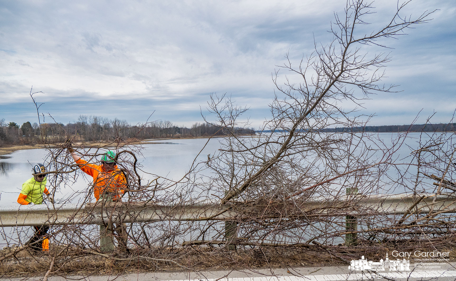A work crew removes trees and shrubs growing in rocks in the base of Smothers Road over Hoover Reservoir preventing the plant's roots from damaging the important structure and blocking views of the lake. My Final Photo for January 11, 2023. 