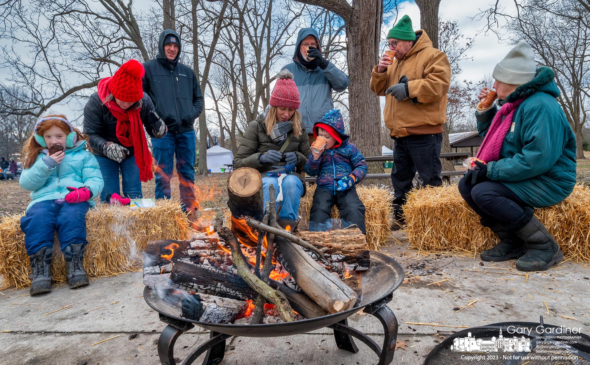 Families gather around a fire and drink hot chocolate after finishing the Winter Hike in Sharon Woods Metro Park Saturday. My Final Photo for January 14, 2023.