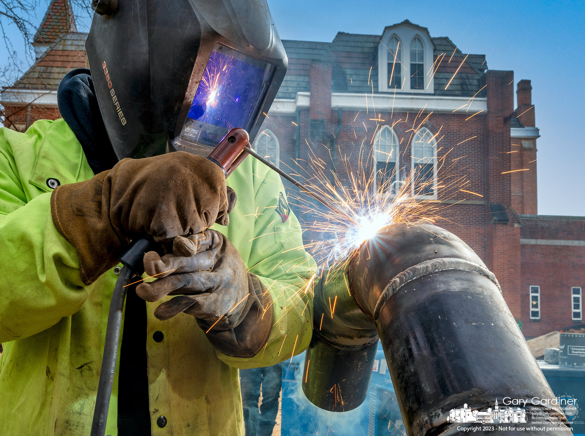 A welder fabricates a section of iron pipe that replaces portions of a pressurized 300-degree water heating system that failed filling the building with steam while students were on break. My Final Photo for February 8, 2023.