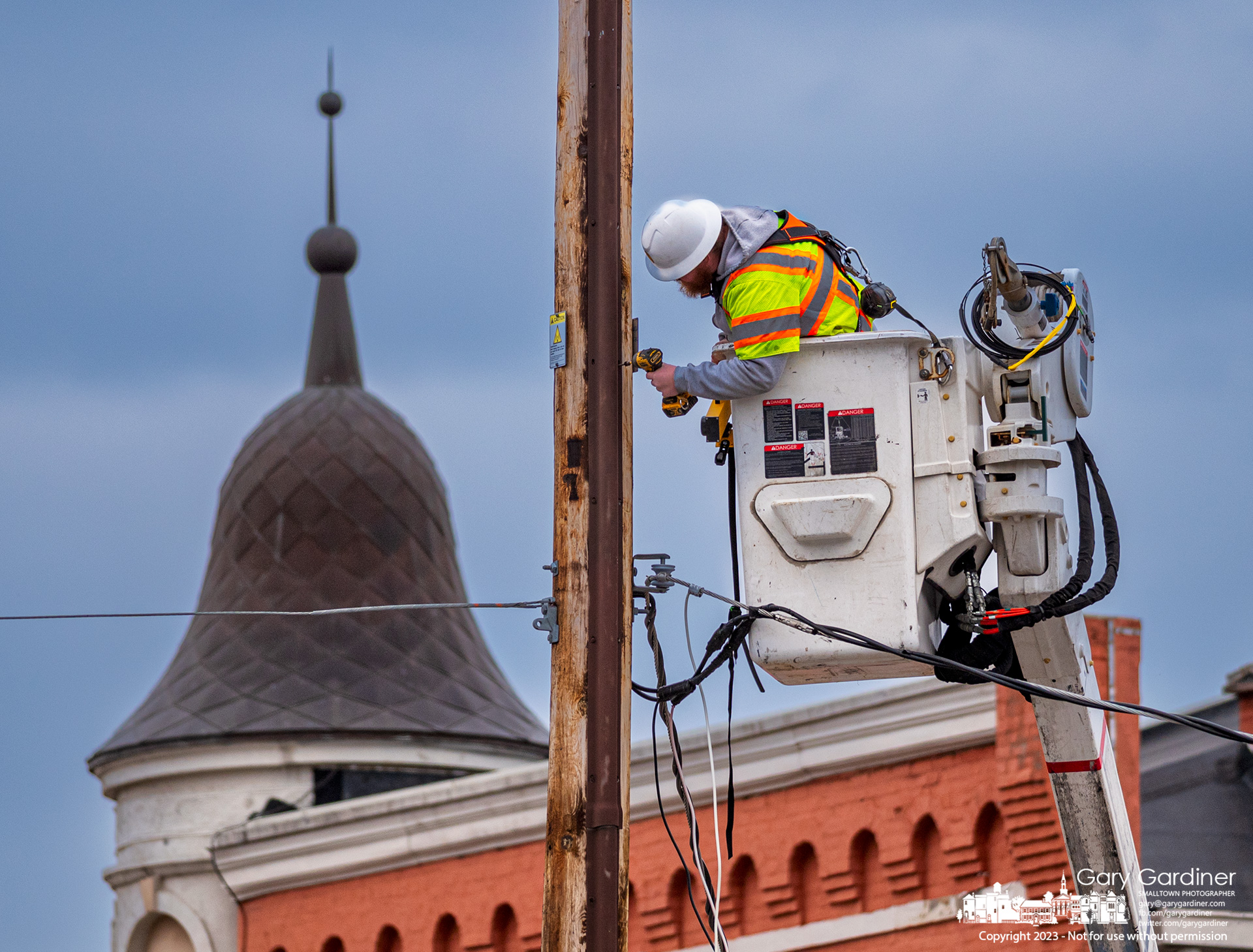 A technician fastens cables to a utility pole on West Main Street as part of an upgrade for cellular telephones in the Uptown Business District. My Final Photo for February 20, 2023.