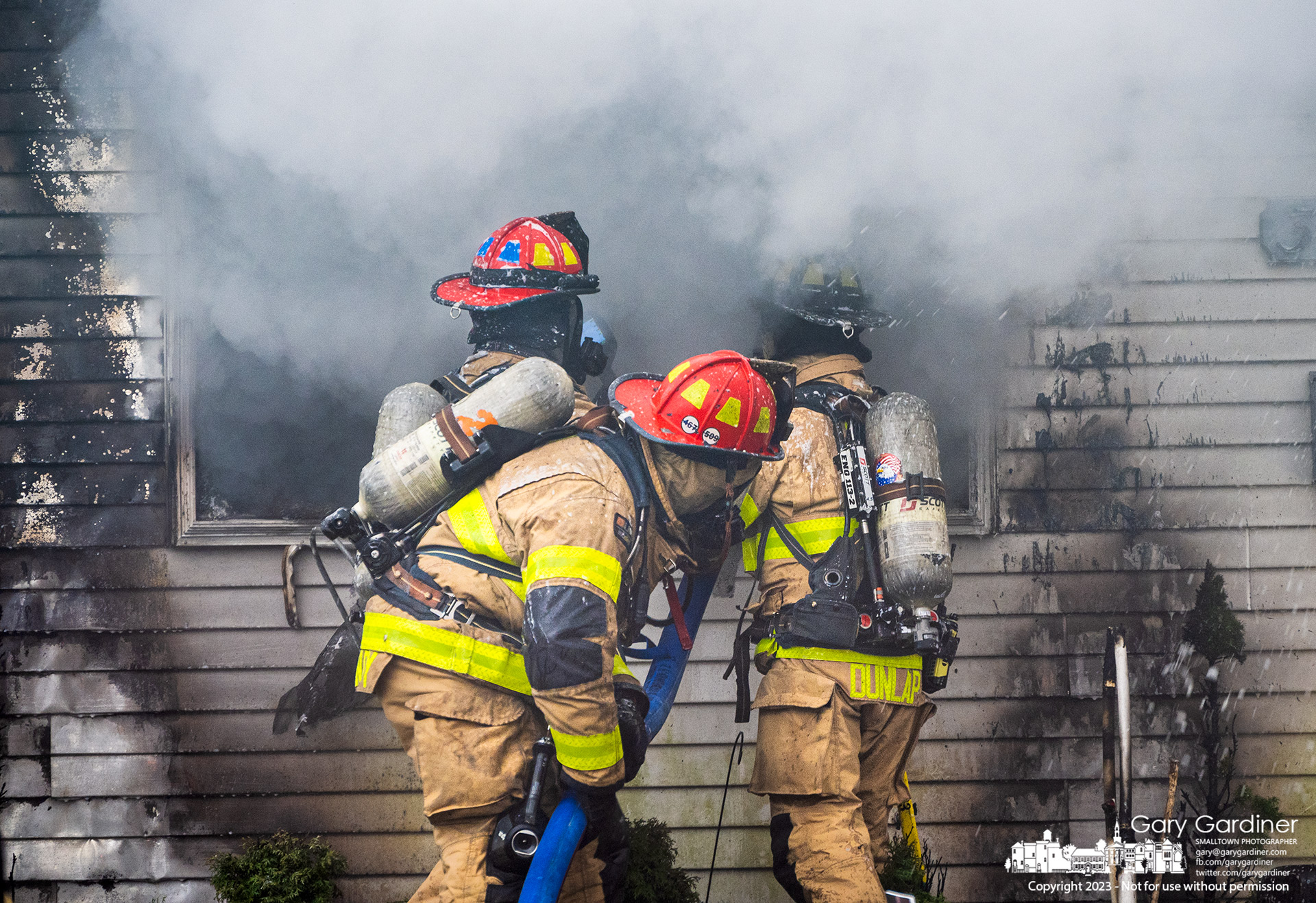 Firefighters guide a hose through the front window of a house In Huber Ridge that was heavily damaged by fire requiring assistance for Westerville by four other departments. My Final Photo for March 31, 2023.