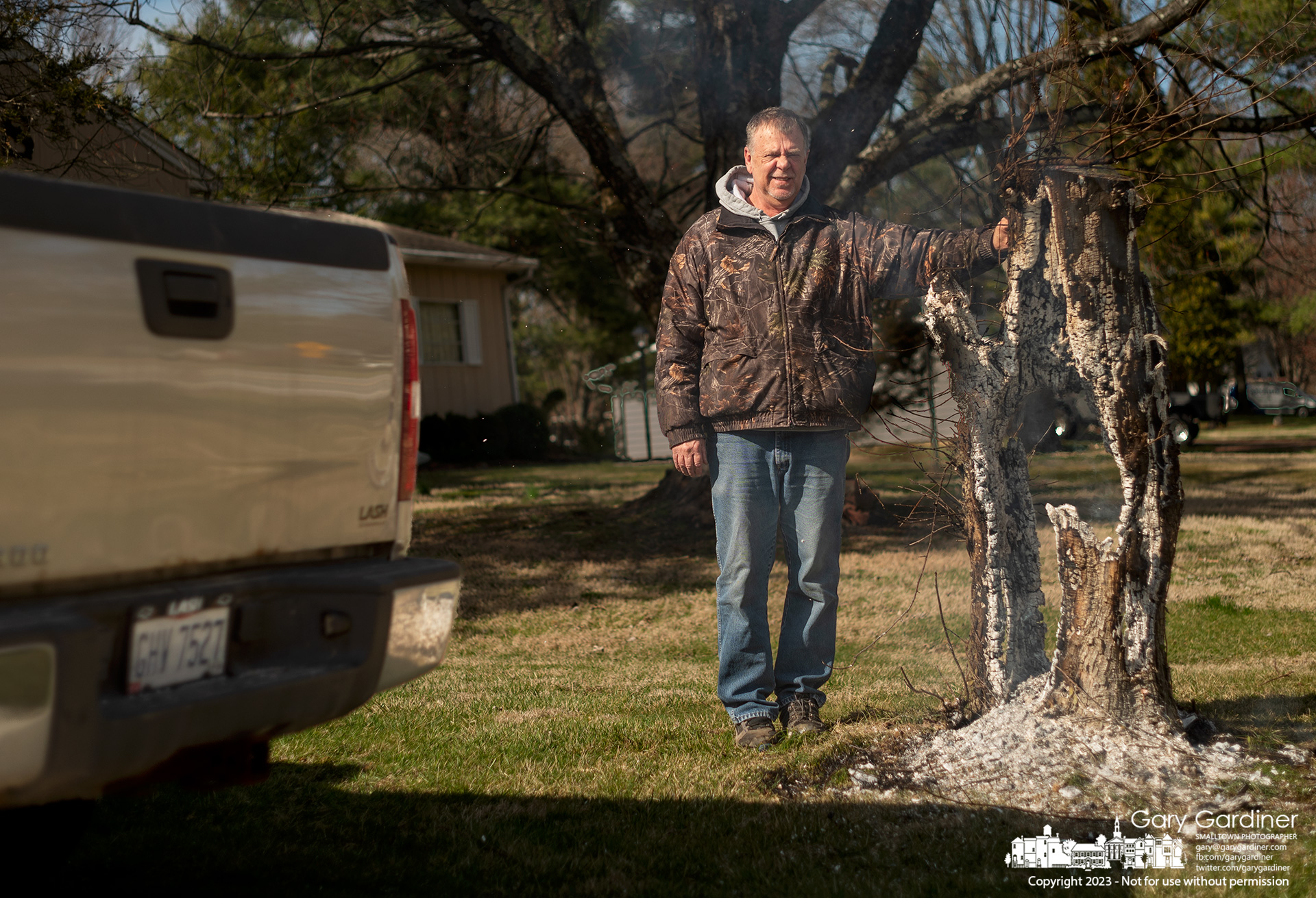 Terry Tuller poses with the crabapple tree stump burning in his front yard in an effort to complete the task of removing the tree that recently died and was cut down. My Final Photo for March 5, 2023.