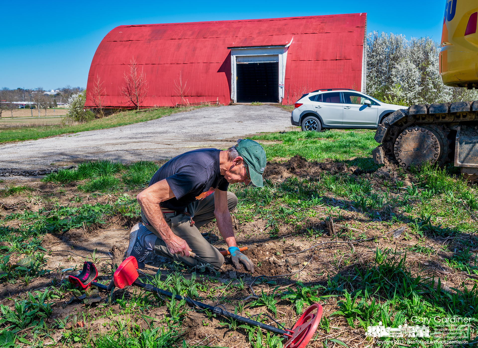 Detectorist Bill  Dawson digs into the soil beneath where the 1882 marker at the Braun Farm once sat looking for the metal object his detector alerted him to as he walked the area between the barn and farmhouse. My Final Photo for April 10, 2023.