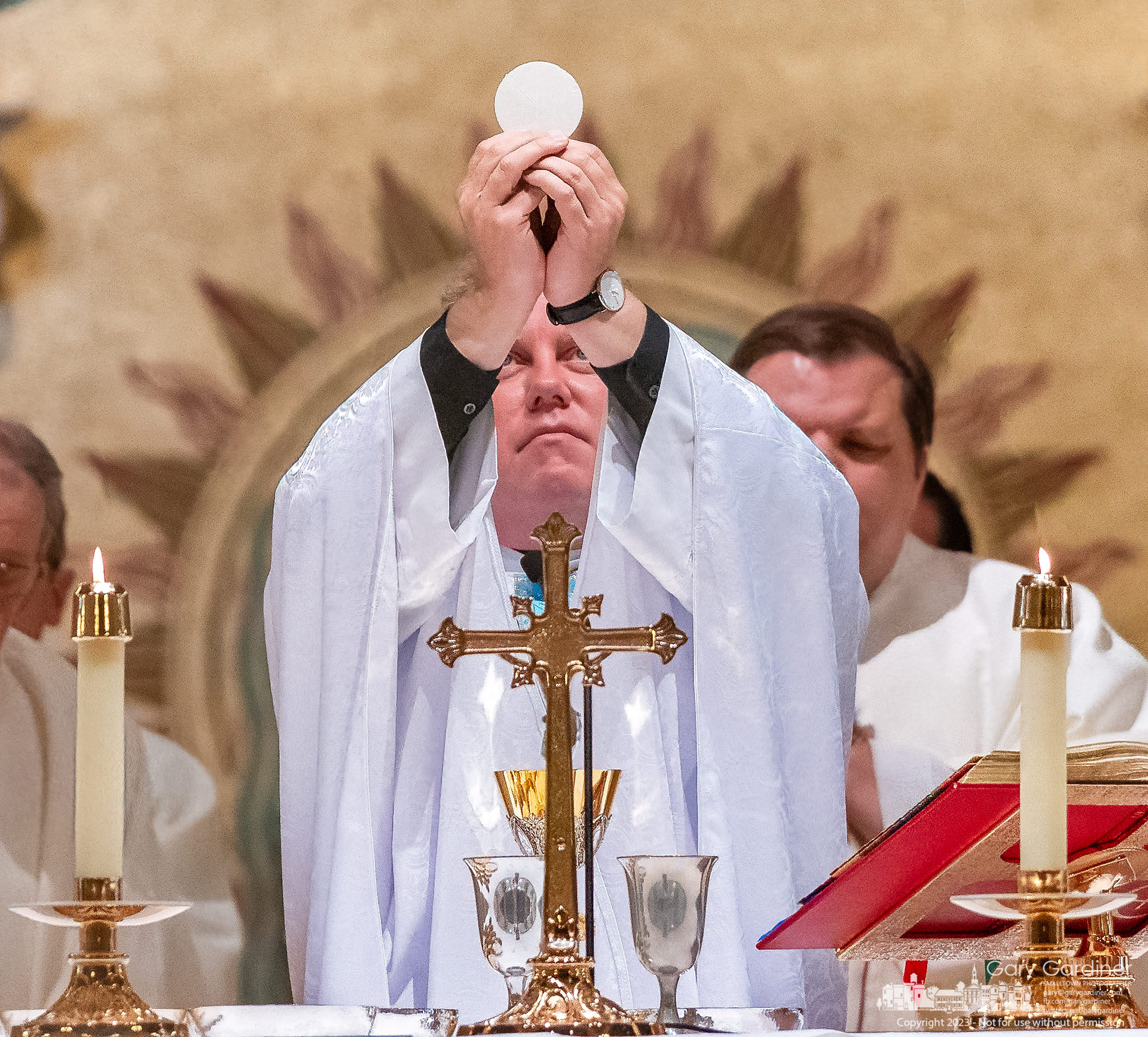 Fr. Jonathan Wilson raises a consecrated host during Mass at St. Paul the Apostle Catholic Church celebrating his serving 20 years as a priest. My Final Photo for May 31, 2023.