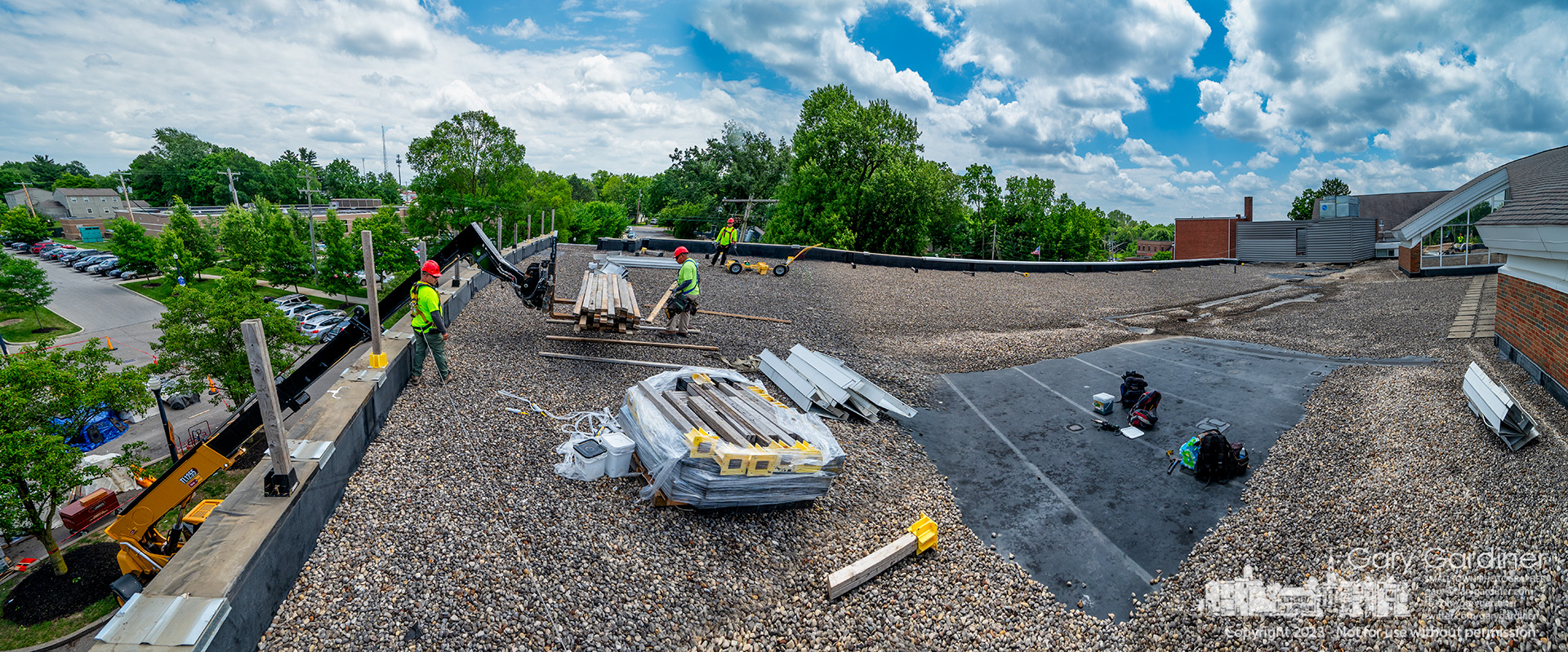 Roofers load building materials and tools onto the roof of the main Westerville Public Library building as they prepare to remove the old gravel-covered bladder roofing for a new metal roof. My Final Photo for June 26, 2023.