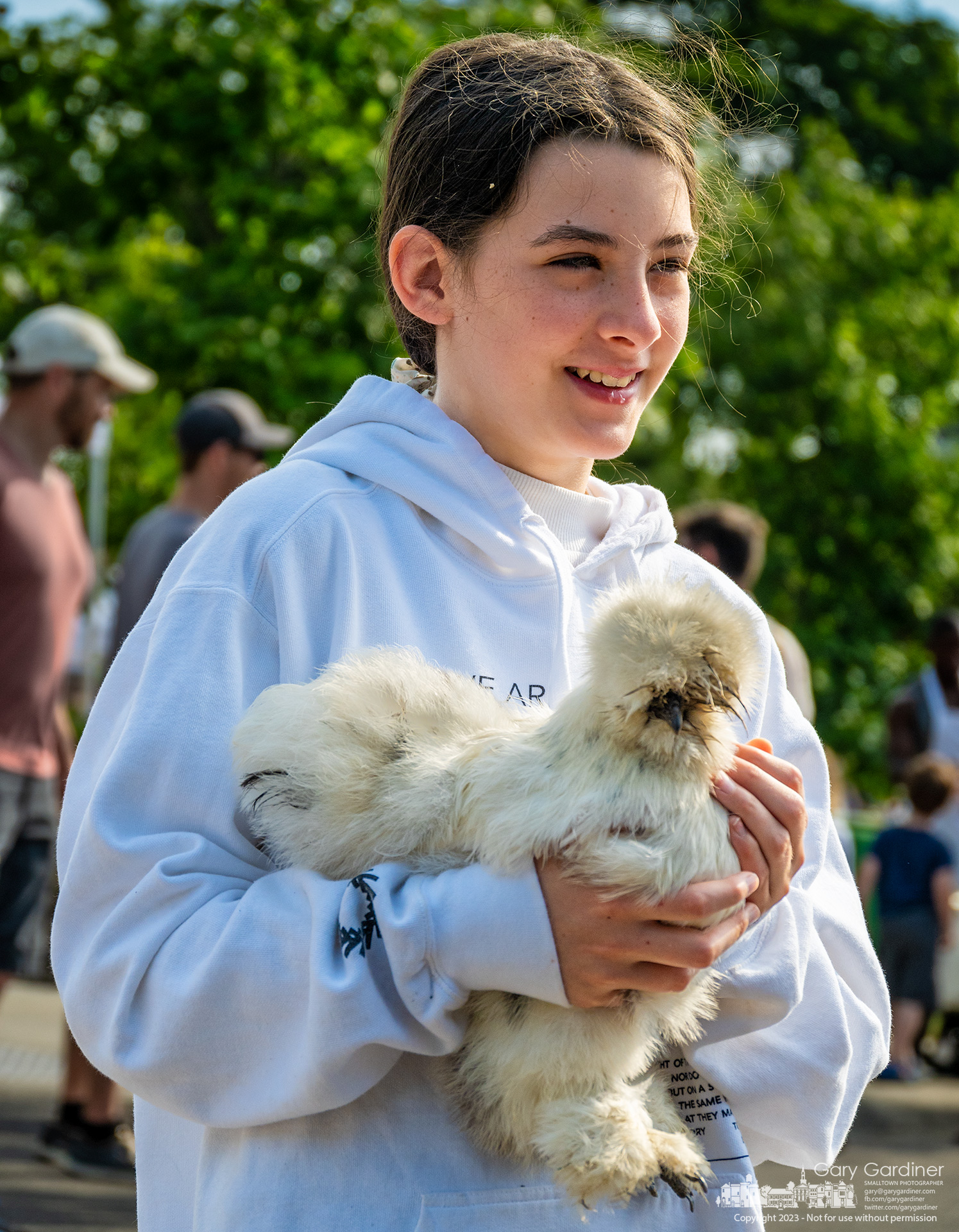 A young girl carries her silky chicken as she shops with her mother and brother at the Saturday Farmers Market in Uptown Westerville. My Final Photo for June 3, 2023.