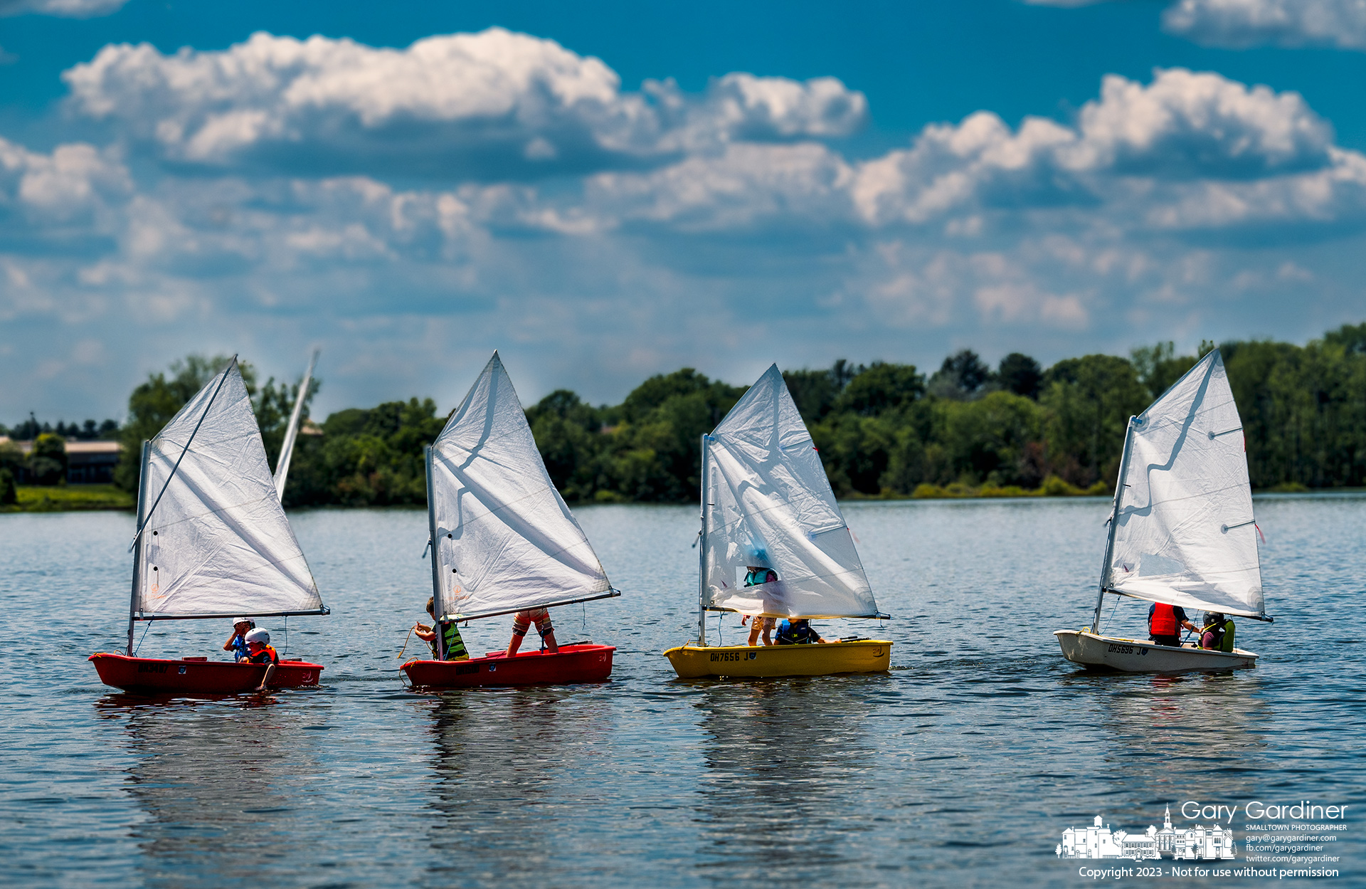 A quartet of two-man sailing teams slowly move in a line toward the docks at the Hoover Sailing Club after completing a sailing lesson on Hoover Reservoir. My Final Photo for July 10, 2023.
