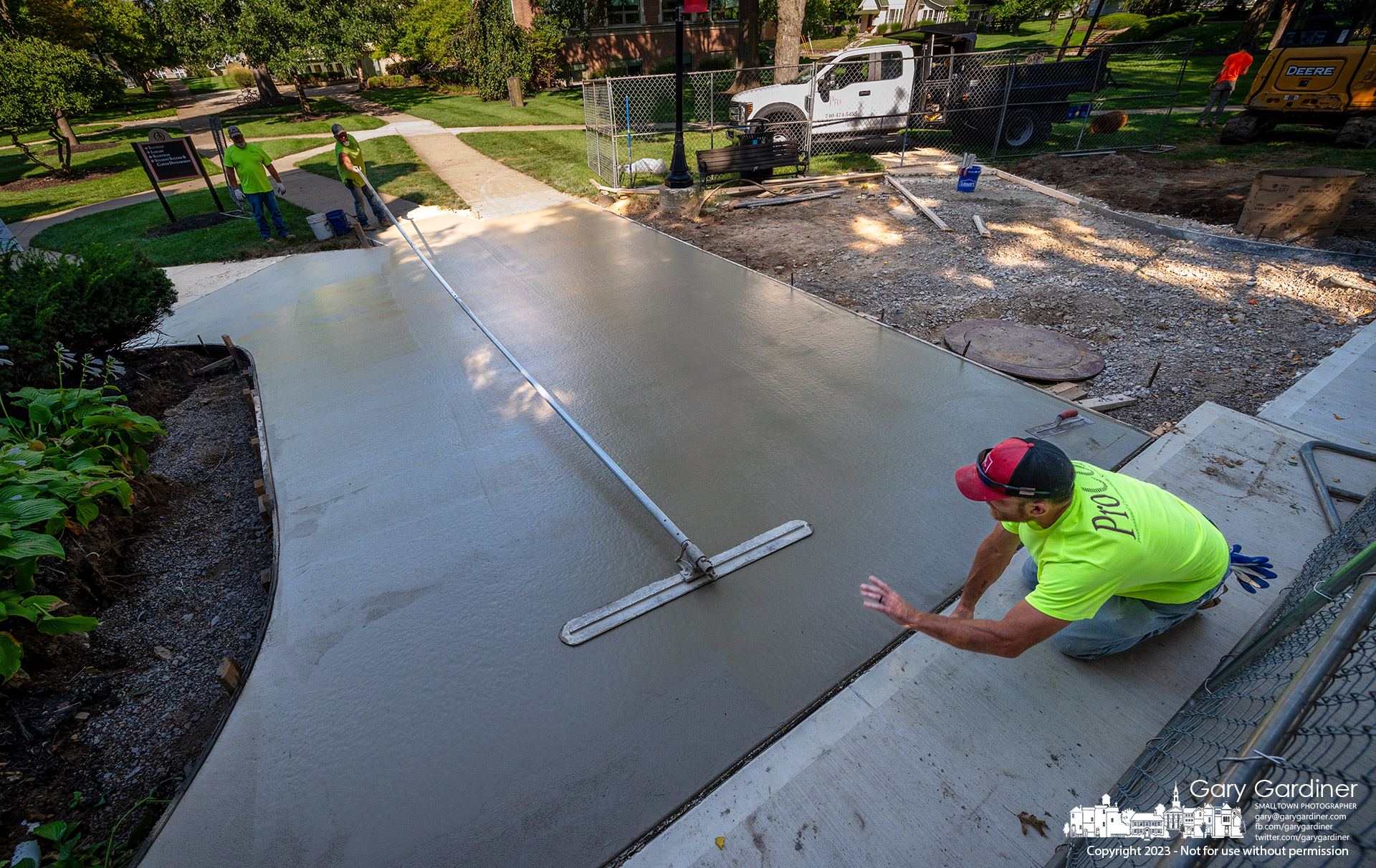 A contractor signals as a bull float levels a large section of concrete sidewalk poured at Towers Hall on the Otterbein University campus where repairs to old and damaged high pressure steam pipes was recently completed. My Final Photo for August 28, 2023.