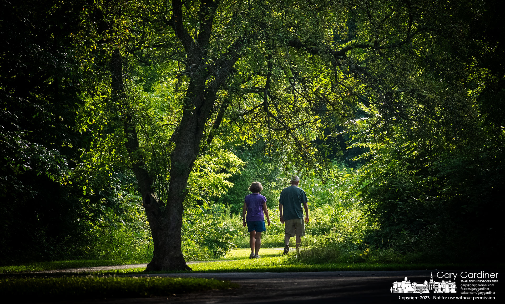 A couple steps into the afternoon sun to continue their walk from a more shaded walkway at Sharon Woods Metro Park Sunday. My Final Photo for August 13, 2023.